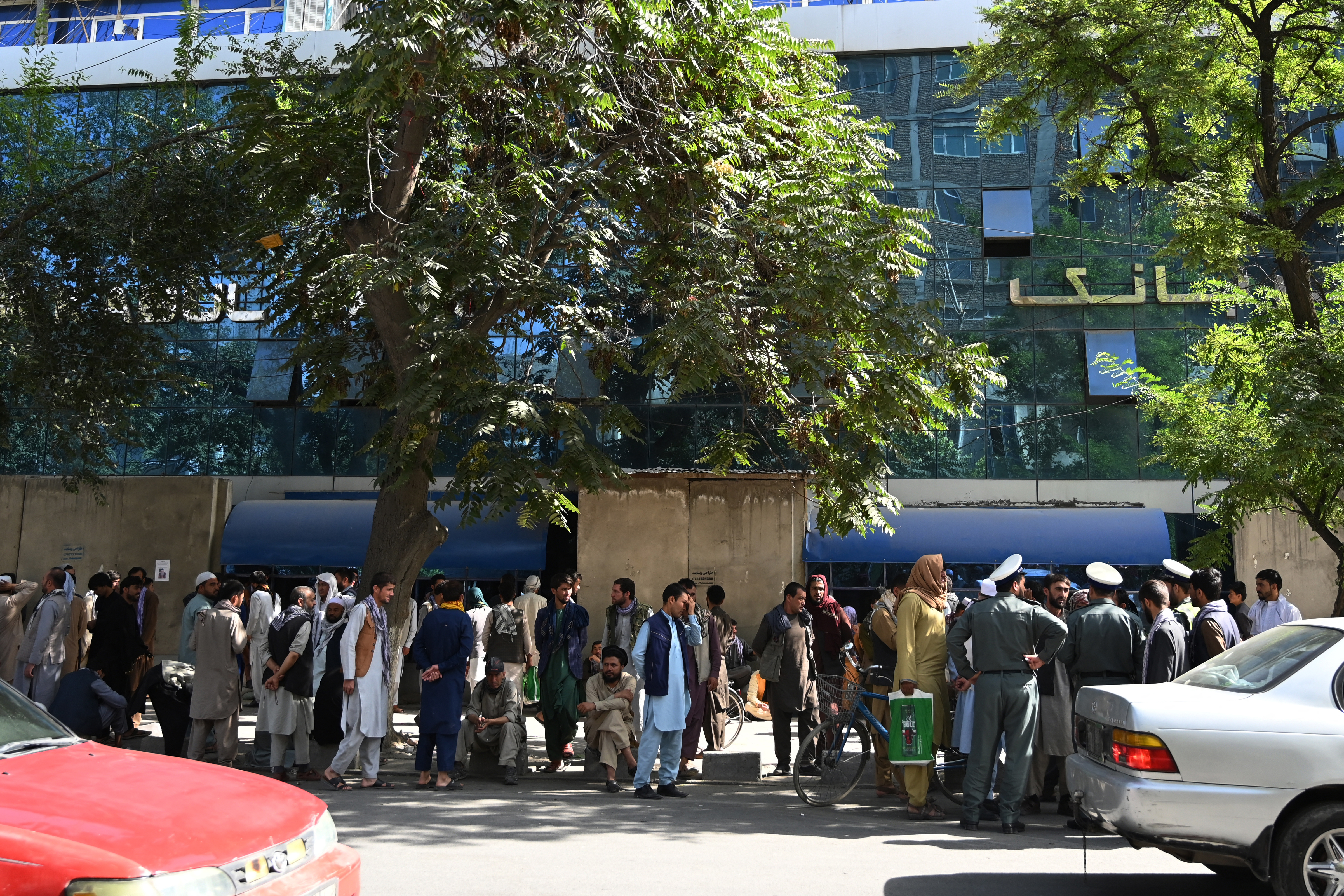 Bank account holders gather outside a closed bank building in Kabul, following the Taliban’s stunning military takeover of Afghanistan