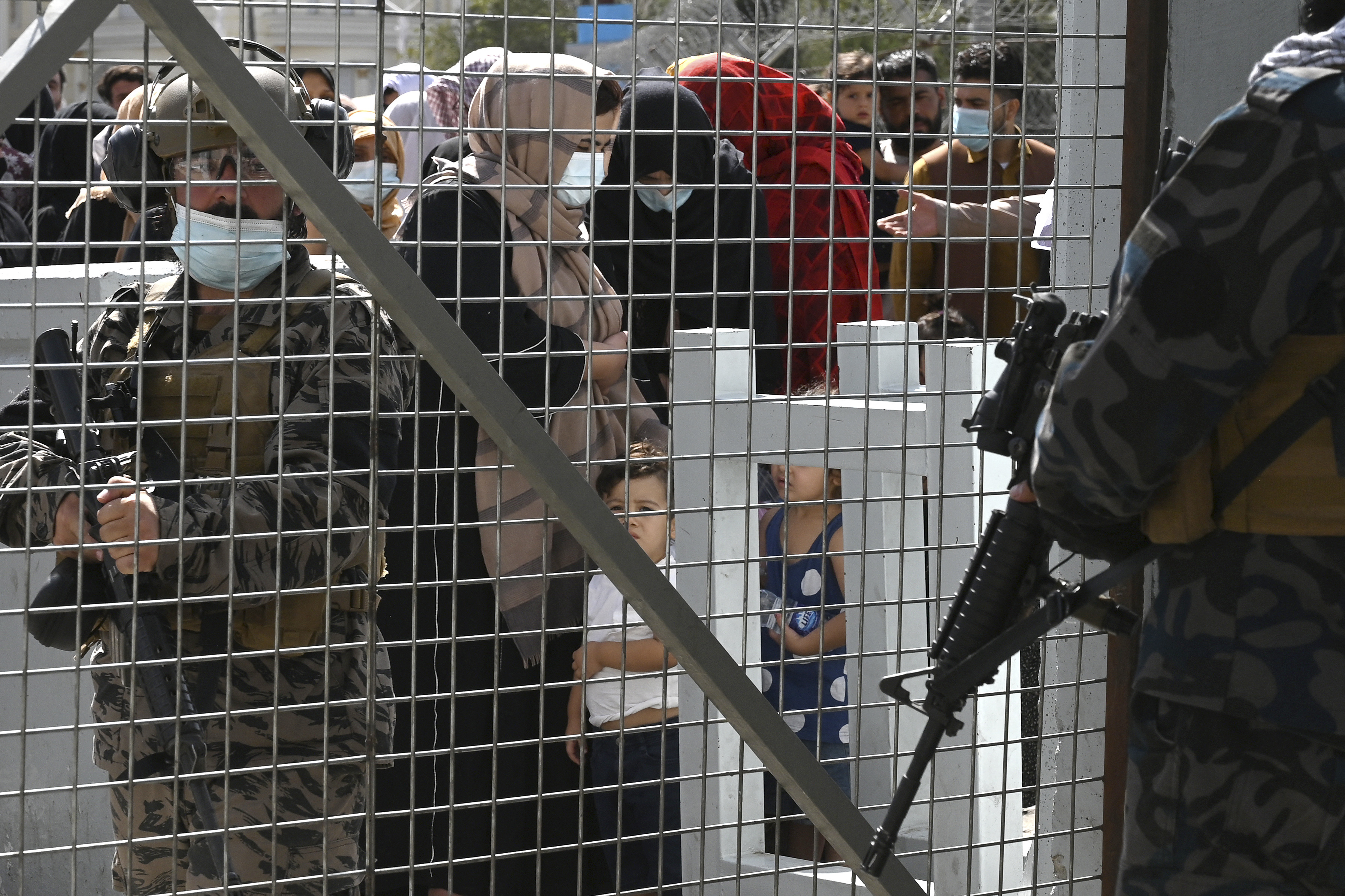 Taliban Badri fighters, a “special forces” unit, stand guard as Afghans, hoping to leave Afghanistan, wait at the main entrance gate of Kabul airport in Kabul