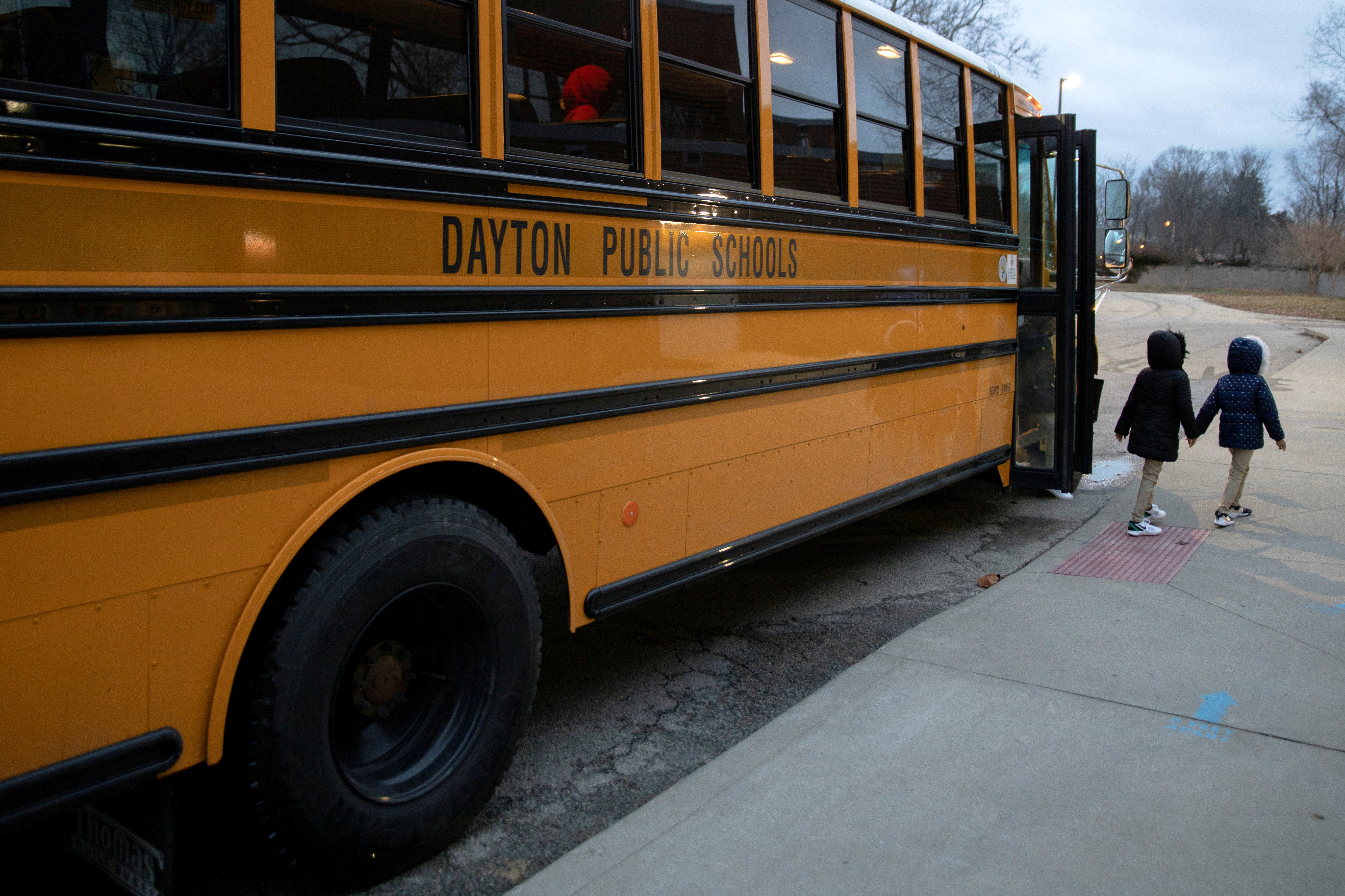 A bus drops students off as classes resume on March 1, 2021, after teachers received the COVID-19 vaccination at Westwood Elementary School in Dayton, Ohio. US states have been divided over mask and vaccination mandates in schools as the Delta variant becomes more widespread
