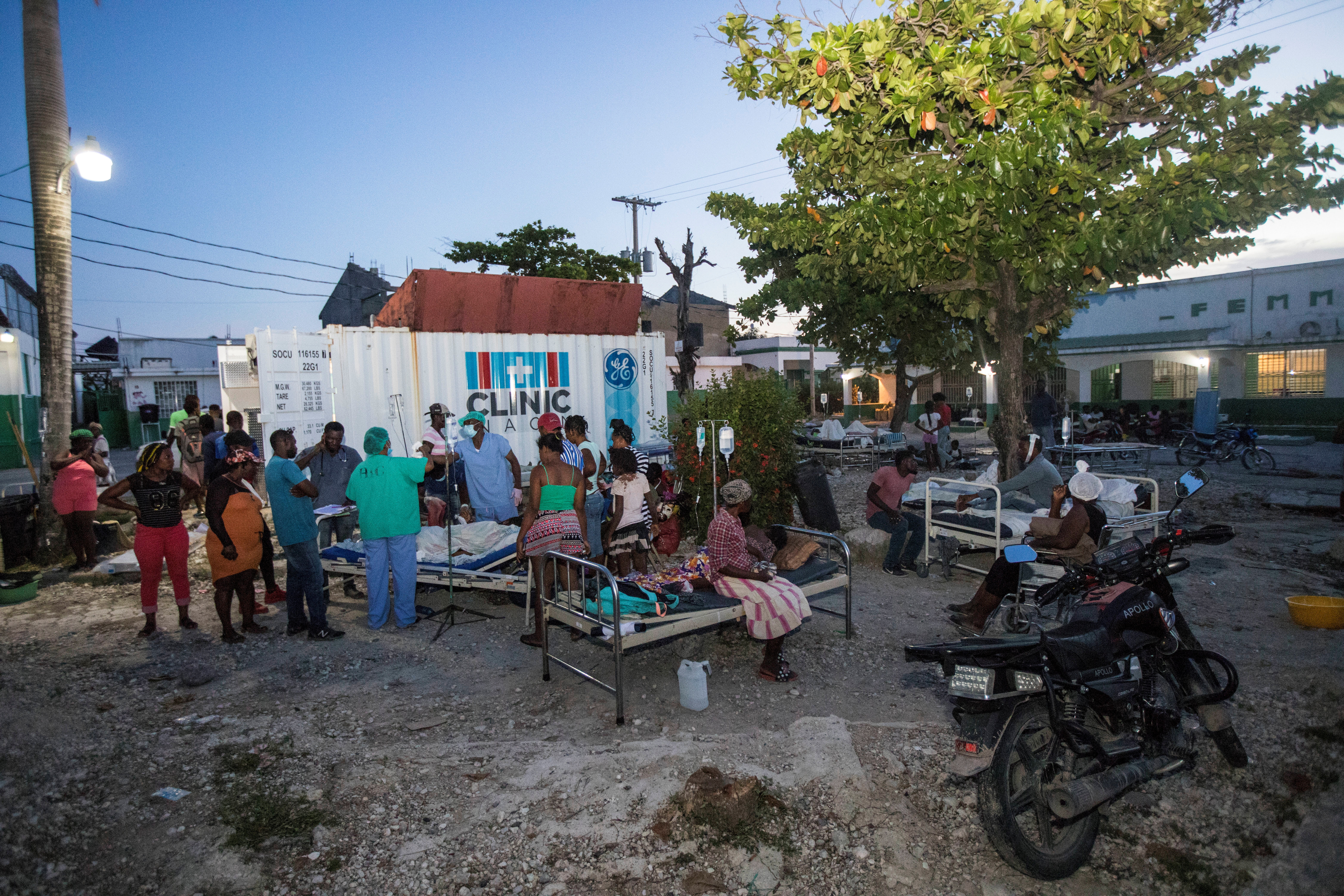 Patients accompanied by relatives are seen outside a hospital damaged following the earthquake