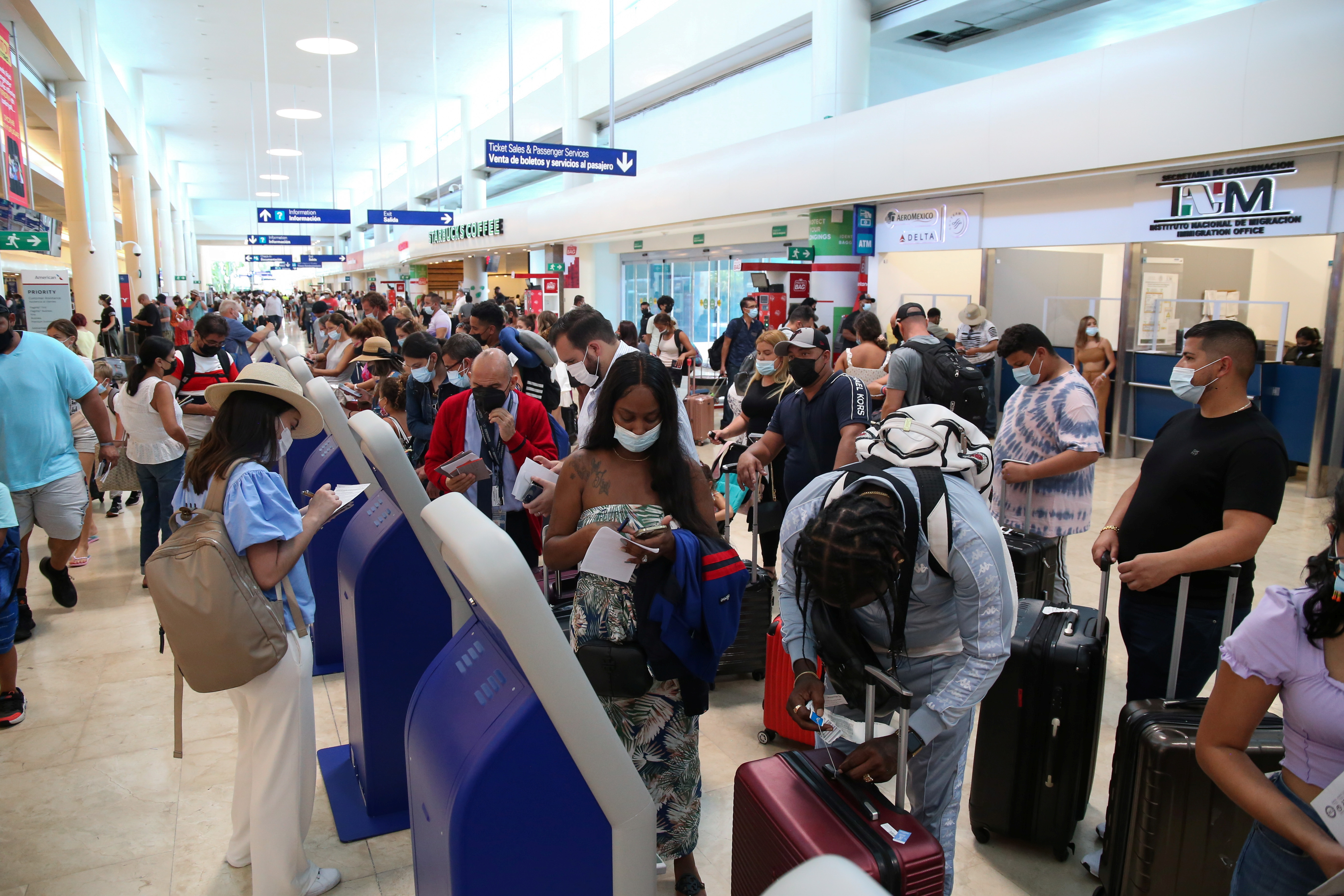 Tourists wait to depart from Cancun’s international airport before the arrival of Hurricane Grace in Cancun, Mexico