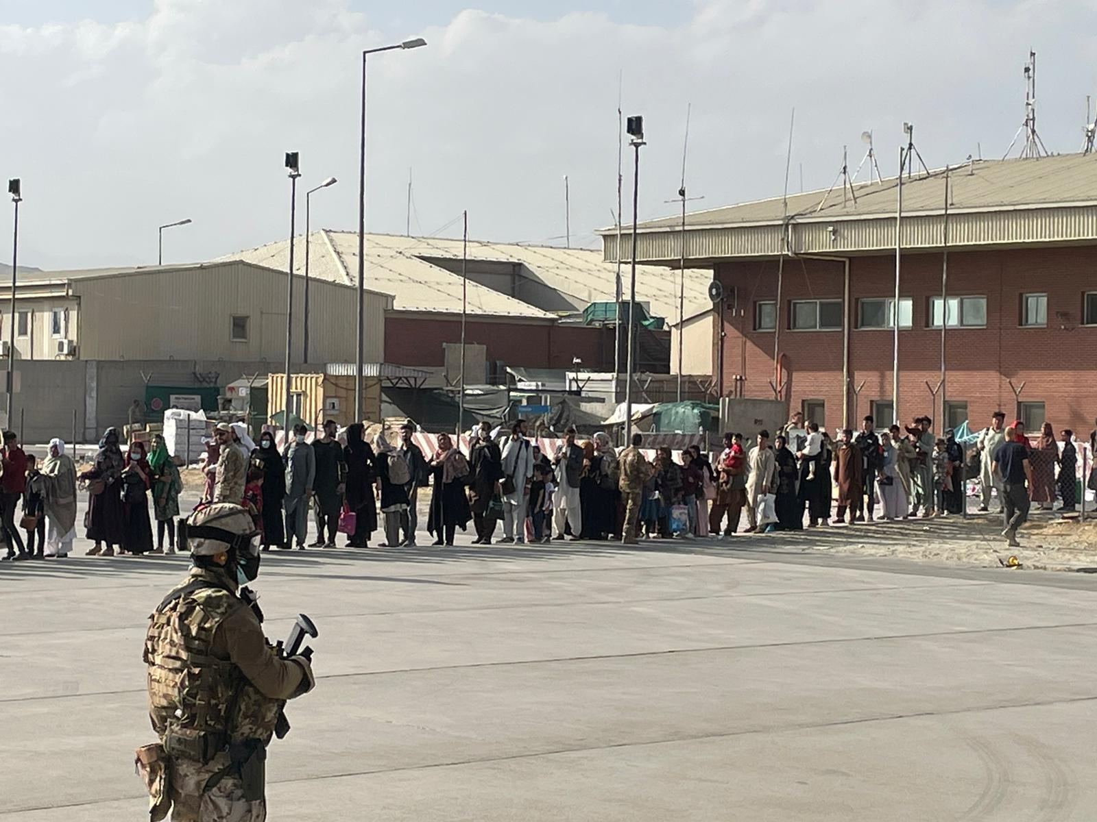 Afghan evacuees queue before boarding one of the last Italian military aircraft flights during the evacuation at Kabul’s airport, Afghanistan