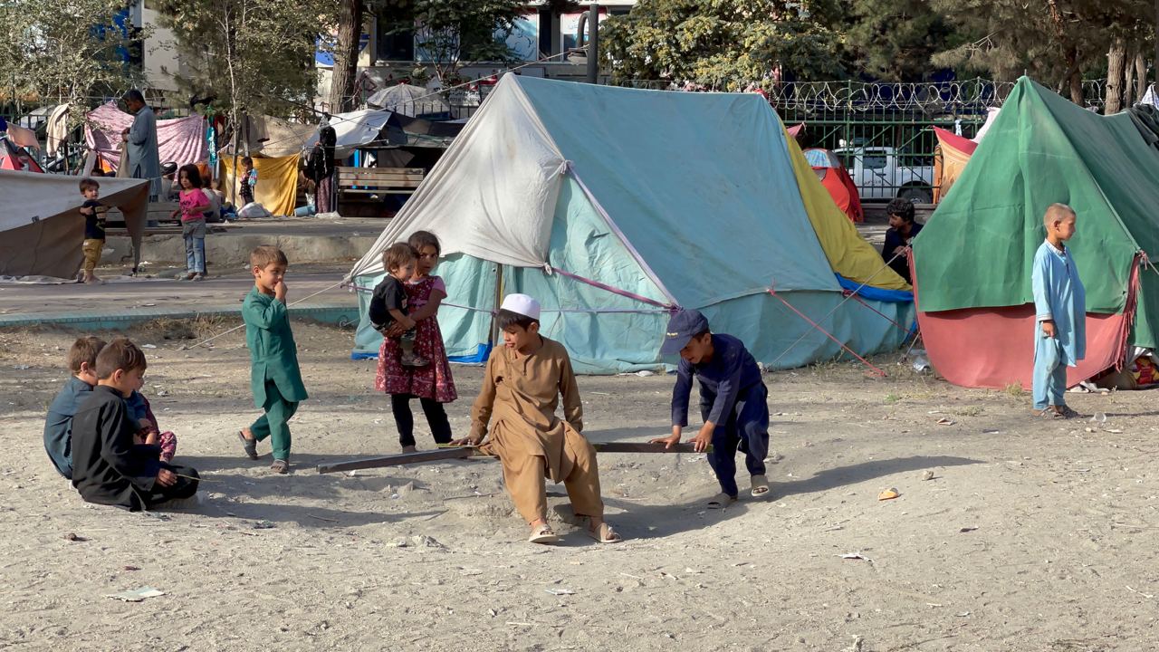 Afghan families continue their lives at the tents they set up at a park in Kabul, Afghanistan