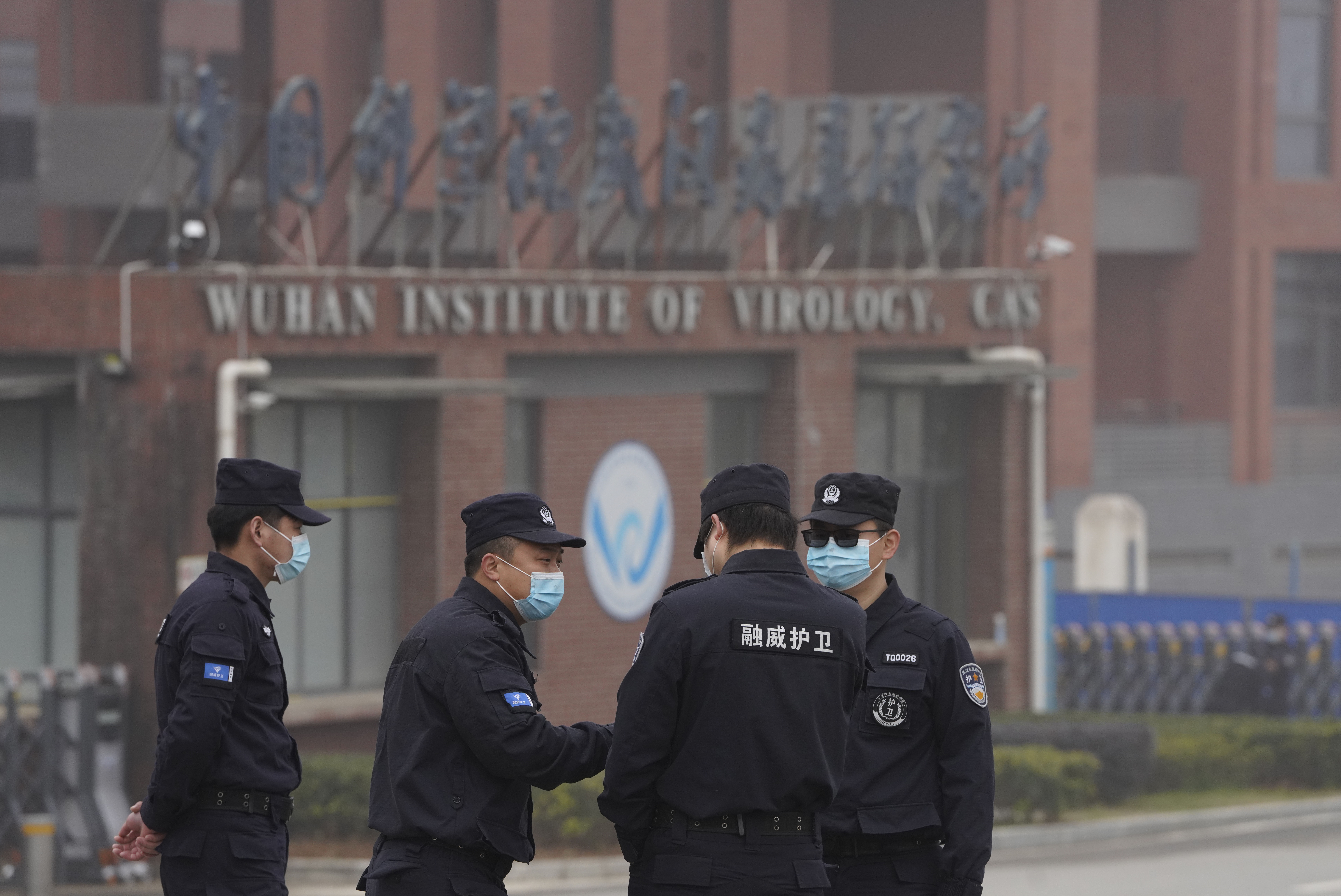 Security personnel gather near the entrance of the Wuhan Institute of Virology during a visit by the World Health Organization team in Wuhan in China’s Hubei province