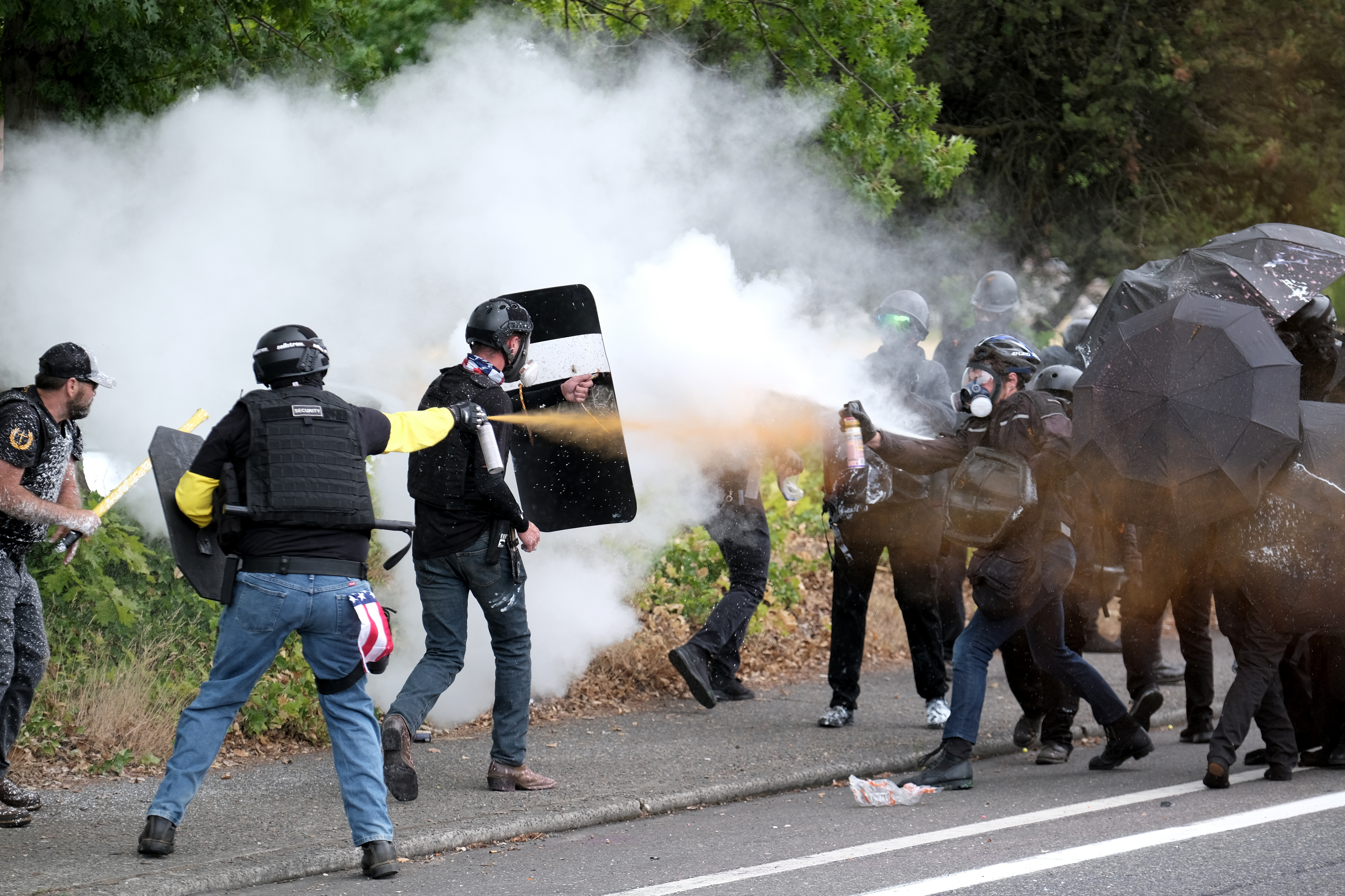 Members of the far-right group Proud Boys and anti-fascist protesters spray bear mace at each other during clashes between the politically opposed groups in August in Portland, Oregon, the US