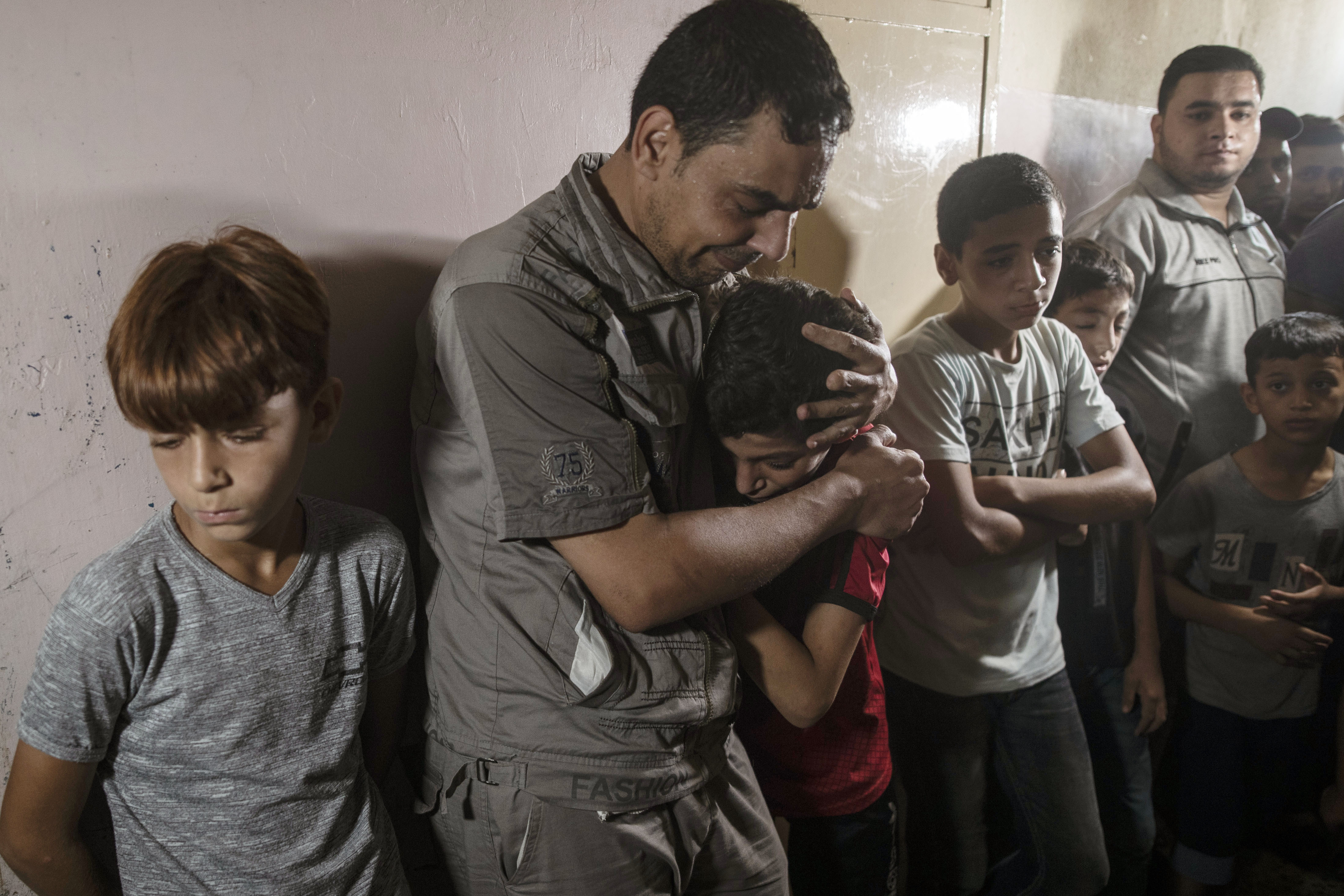 Relatives of Omar Abu al-Neil react during his funeral in the family home in Gaza City