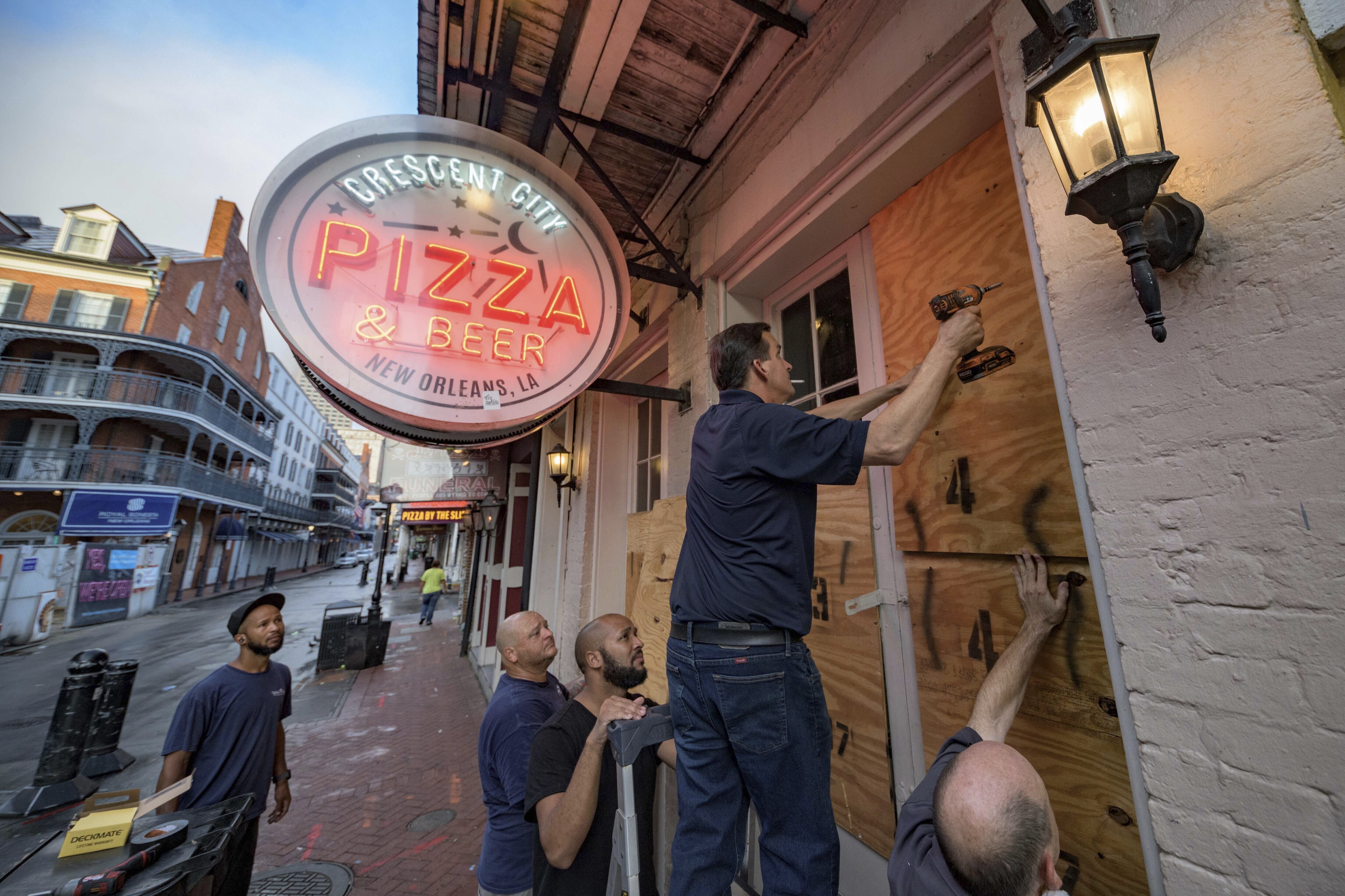 People board up Crescent City Pizza on Bourbon Street in the French Quarter of New Orleans, Louisiana, before landfall of Hurricane Ida