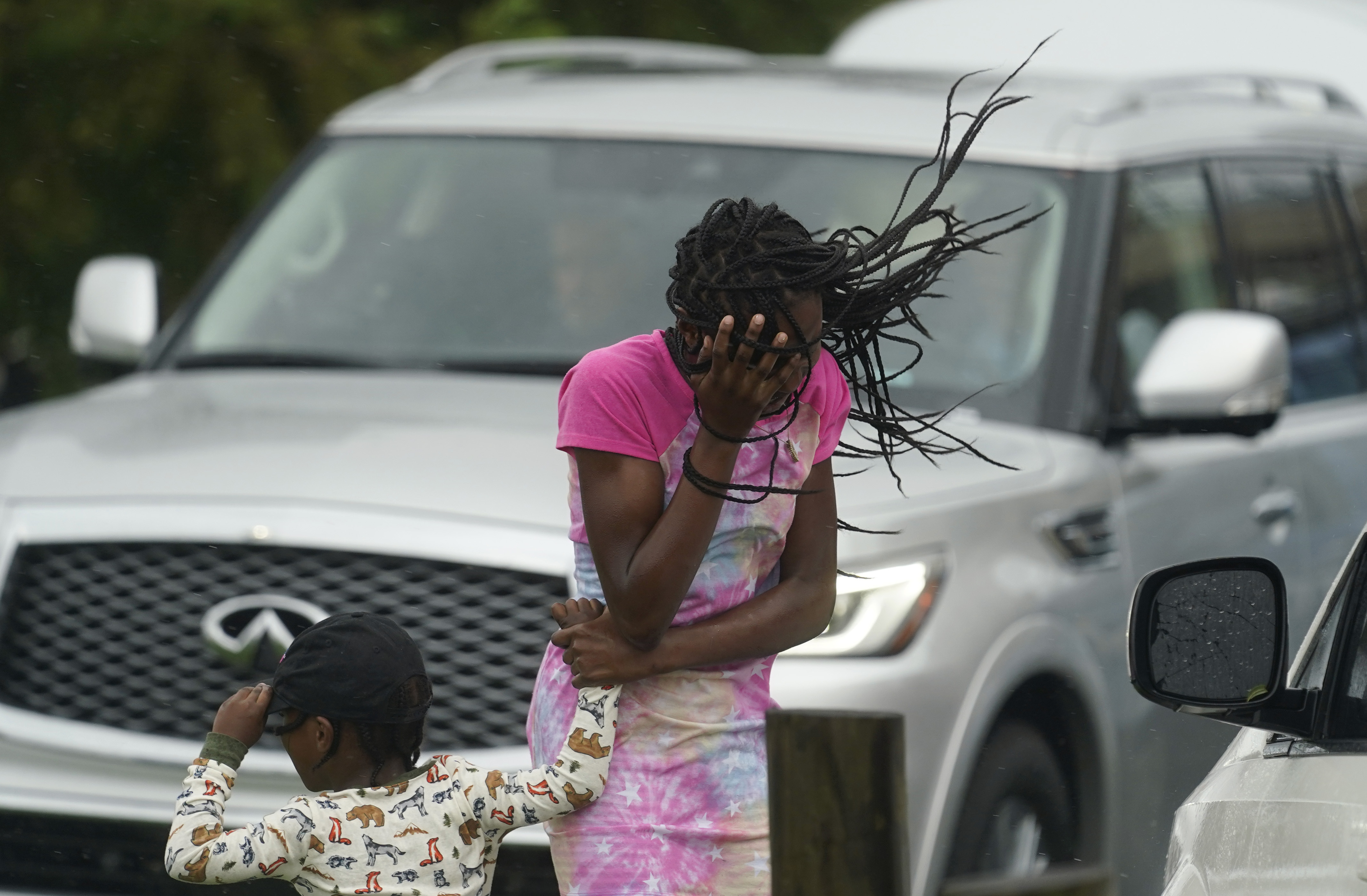 A young girl blocks her face from Hurricane Ida’s wind and rain, August 29, in New Orleans