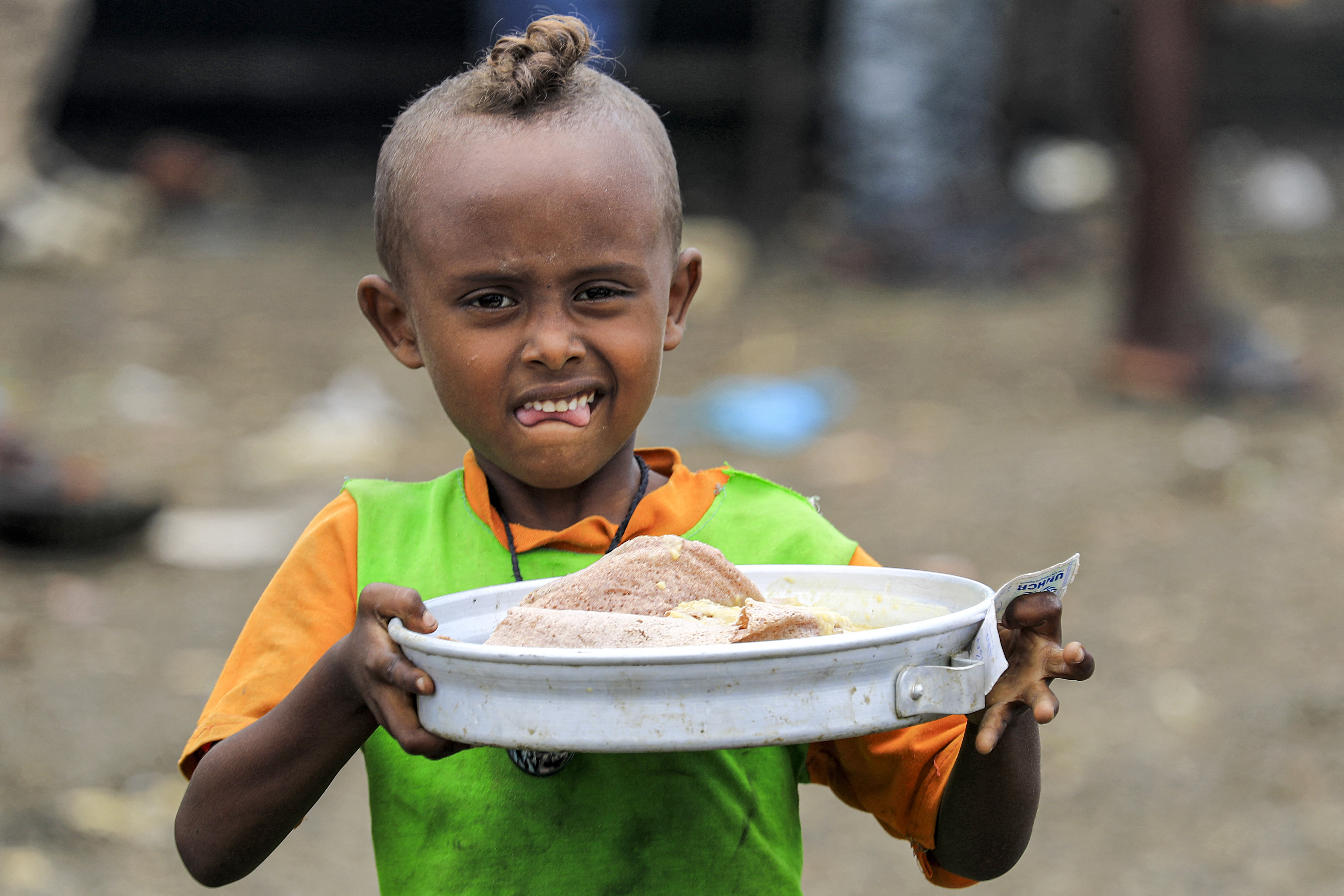 A child from the Qemant ethnic group gathers food at a refugee camp in Sudan