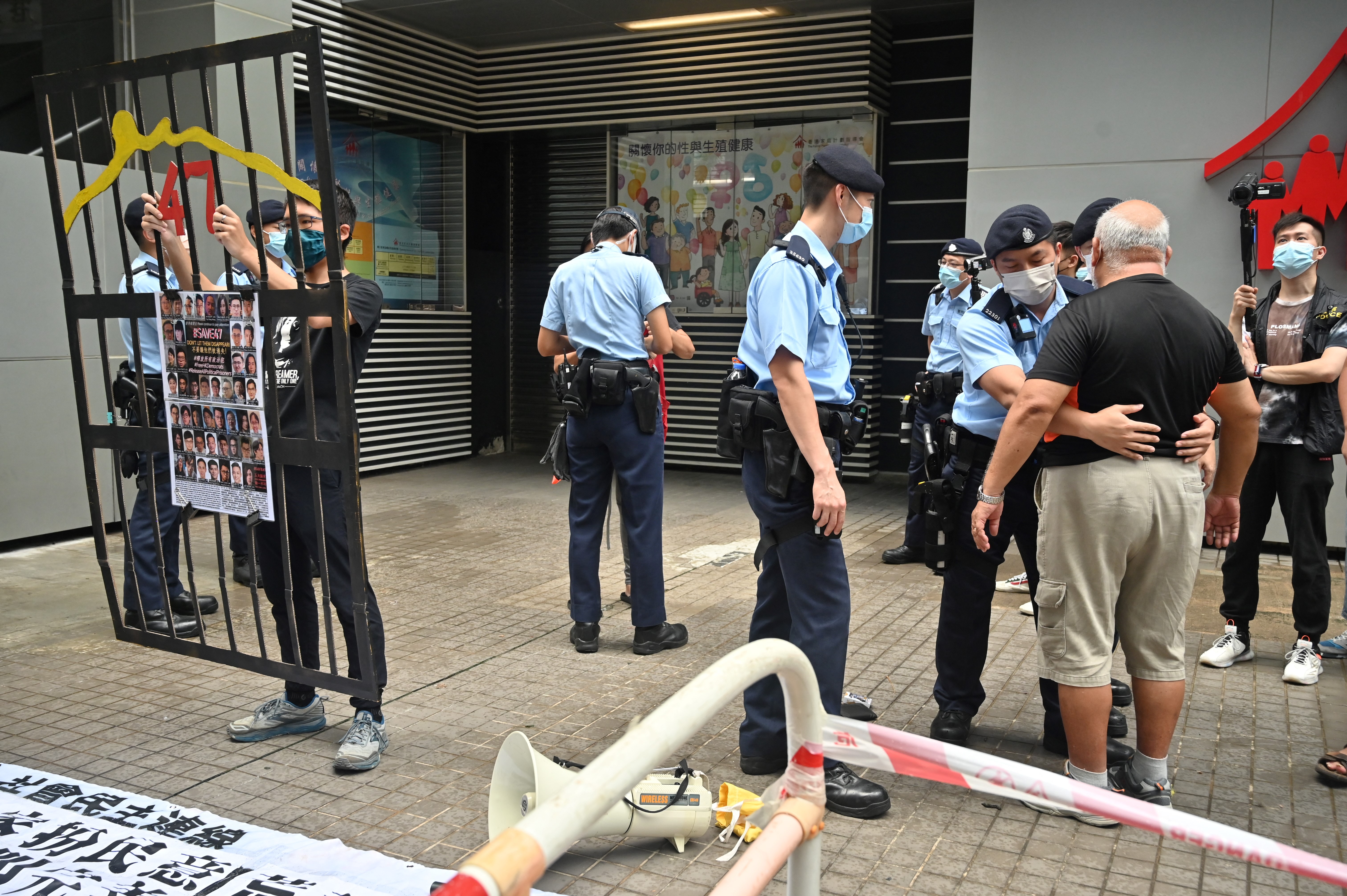 A protester is searched by police as a small group of Hong Kongers began selecting the Election Committee