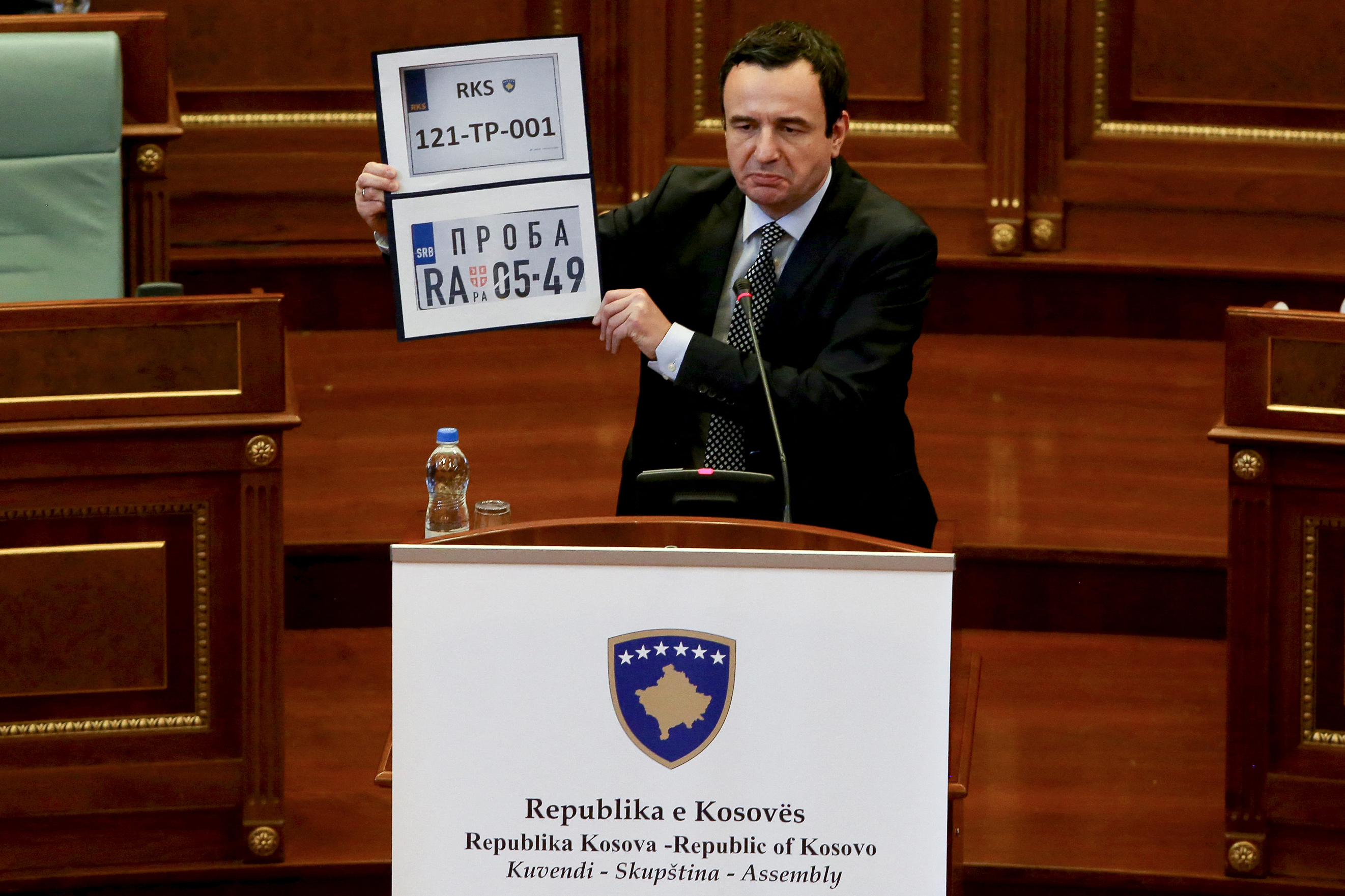 Kosovo Prime Minister Albin Kurti shows Kosovo and Serbia temporary car plates during a parliament session in Pristina [AFP]
