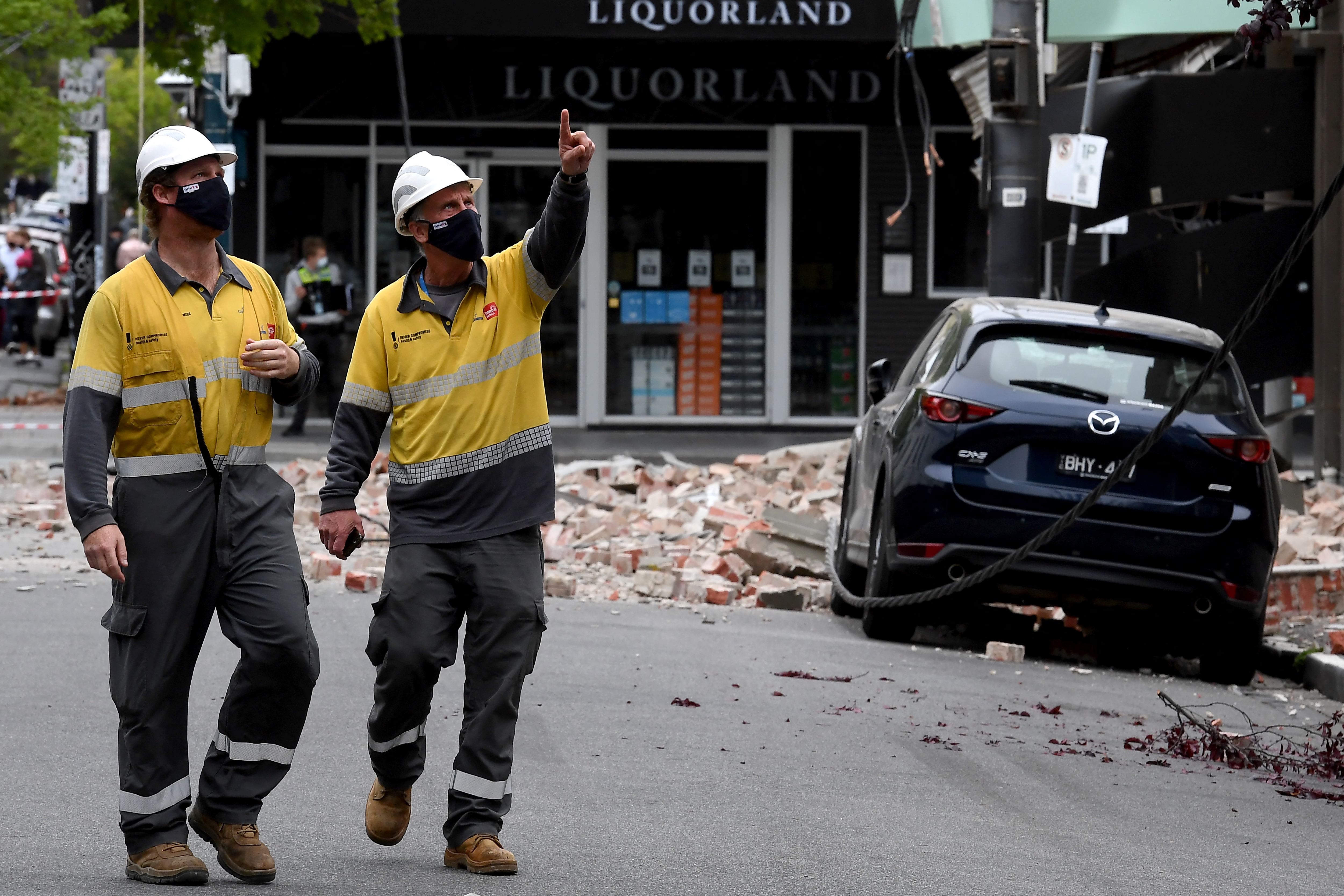 Emergency and rescue workers examine a damaged building in the popular Chapel Street shopping area of Melbourne after a rare earthquake hit the area