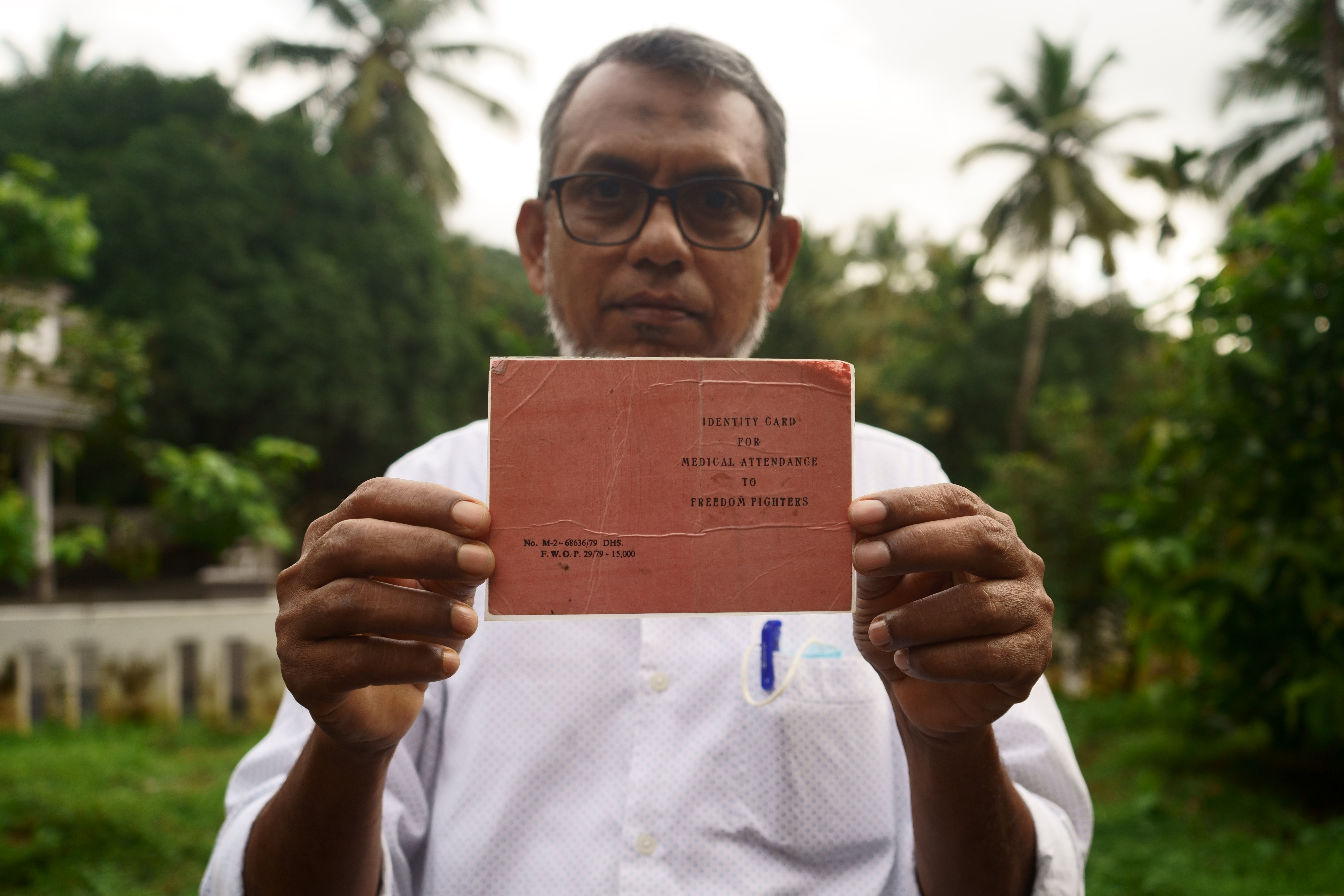 Ibrahim, holding the identity card of an Indian freedom fighter that belonged to his father, Kunjimu
