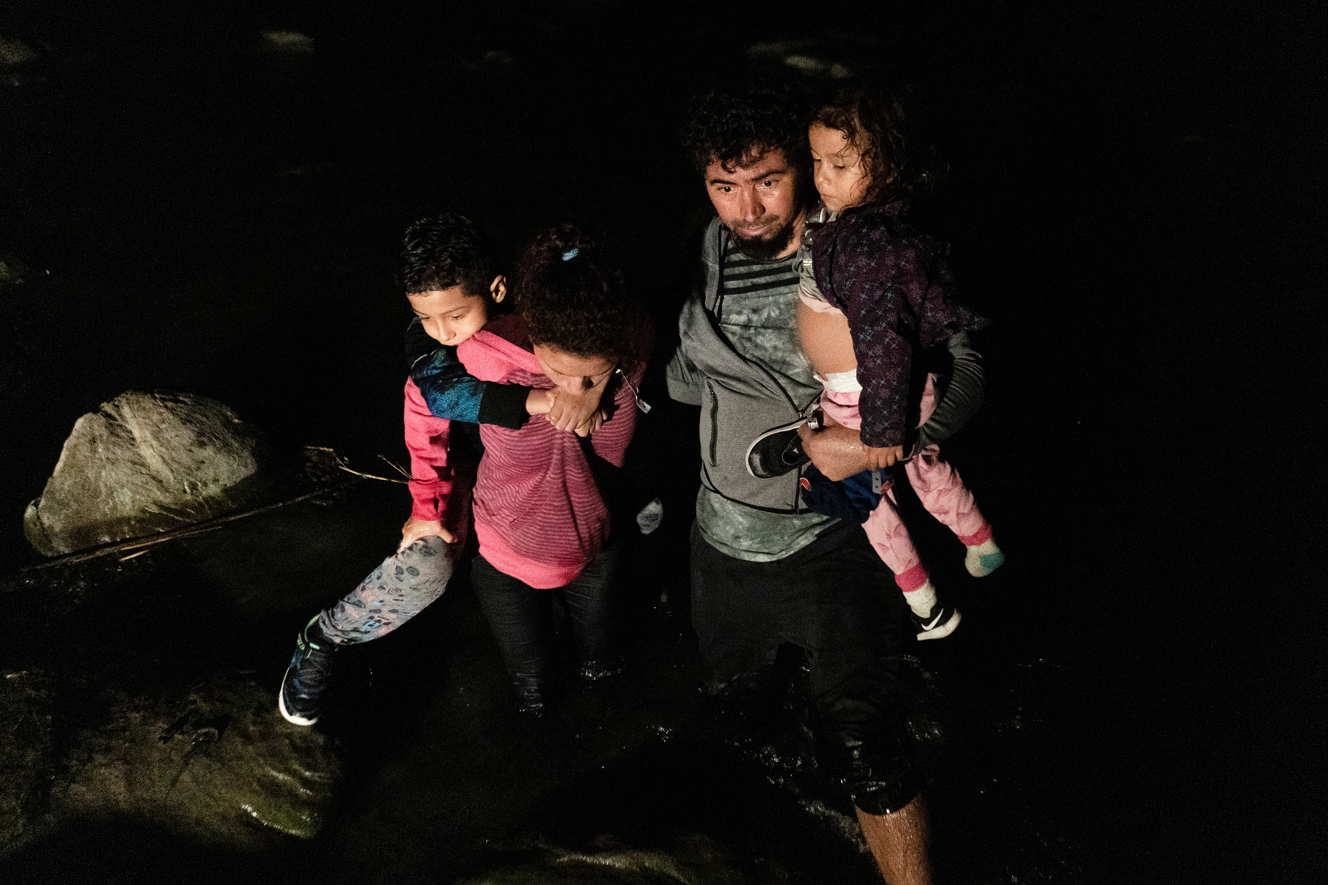 Ecuadorian families arrive to the bank of the Rio Grande River after crossing into the United States from Mexico in Roma, Texas, on July 7 [File: Go Nakamura/Reuters]