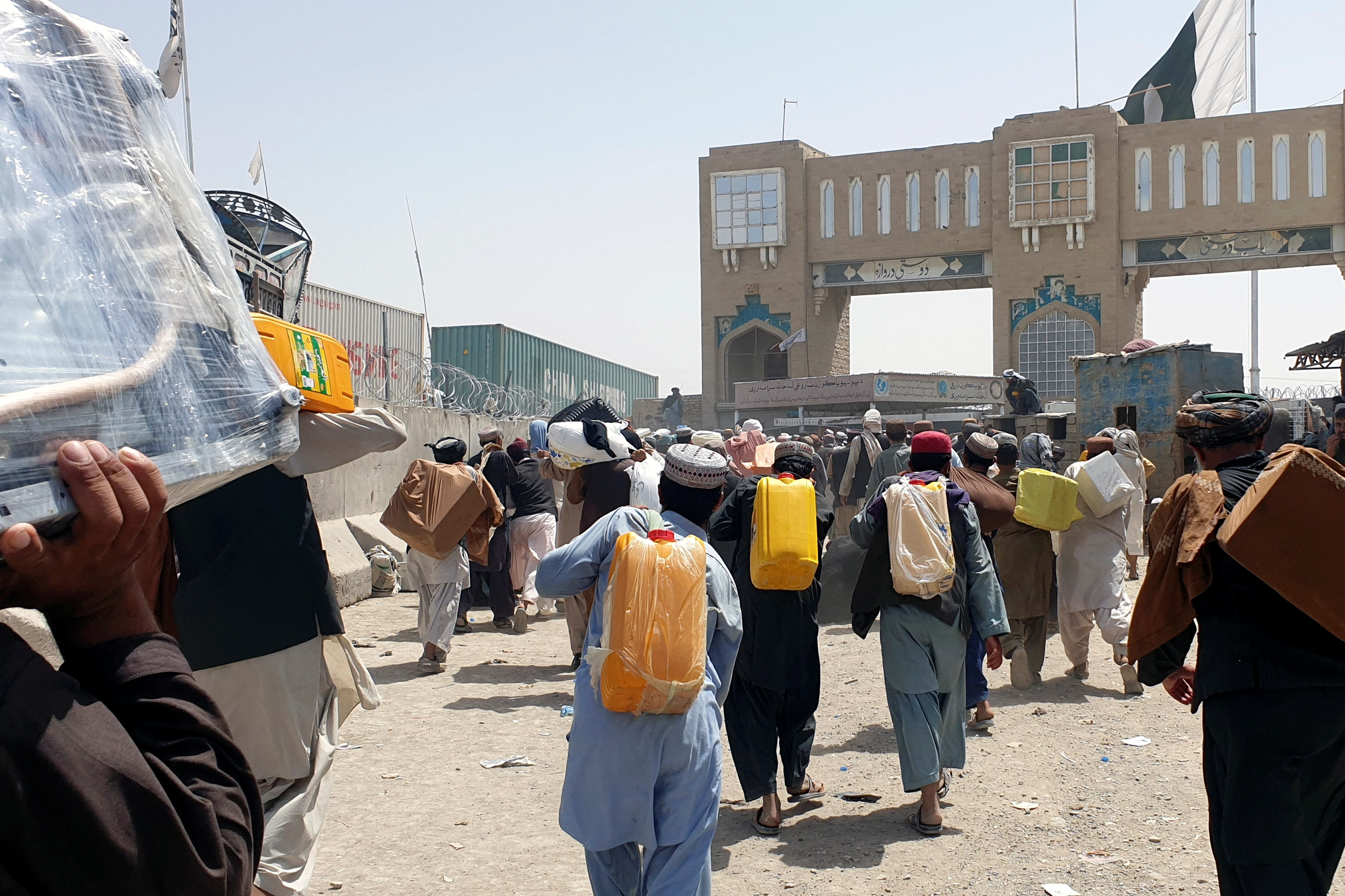 People walk with their belongings to cross into Pakistan at the Friendship Gate crossing point, in the Pakistan-Afghanistan border town of Chaman, Pakistan September 6, 2021