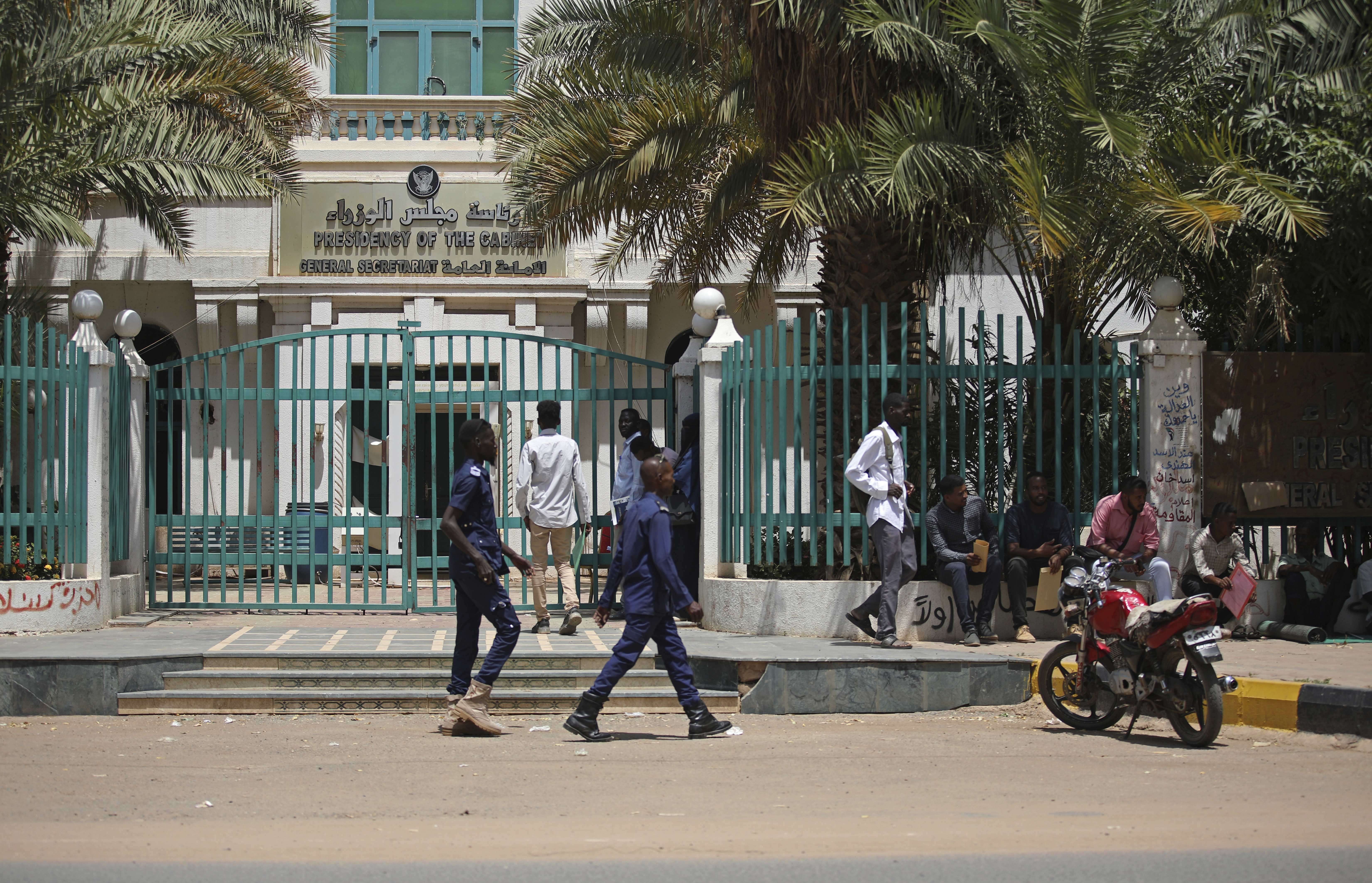 Sudanese soldiers walk in front of the office of the Sudanese Council of Ministers in Khartoum
