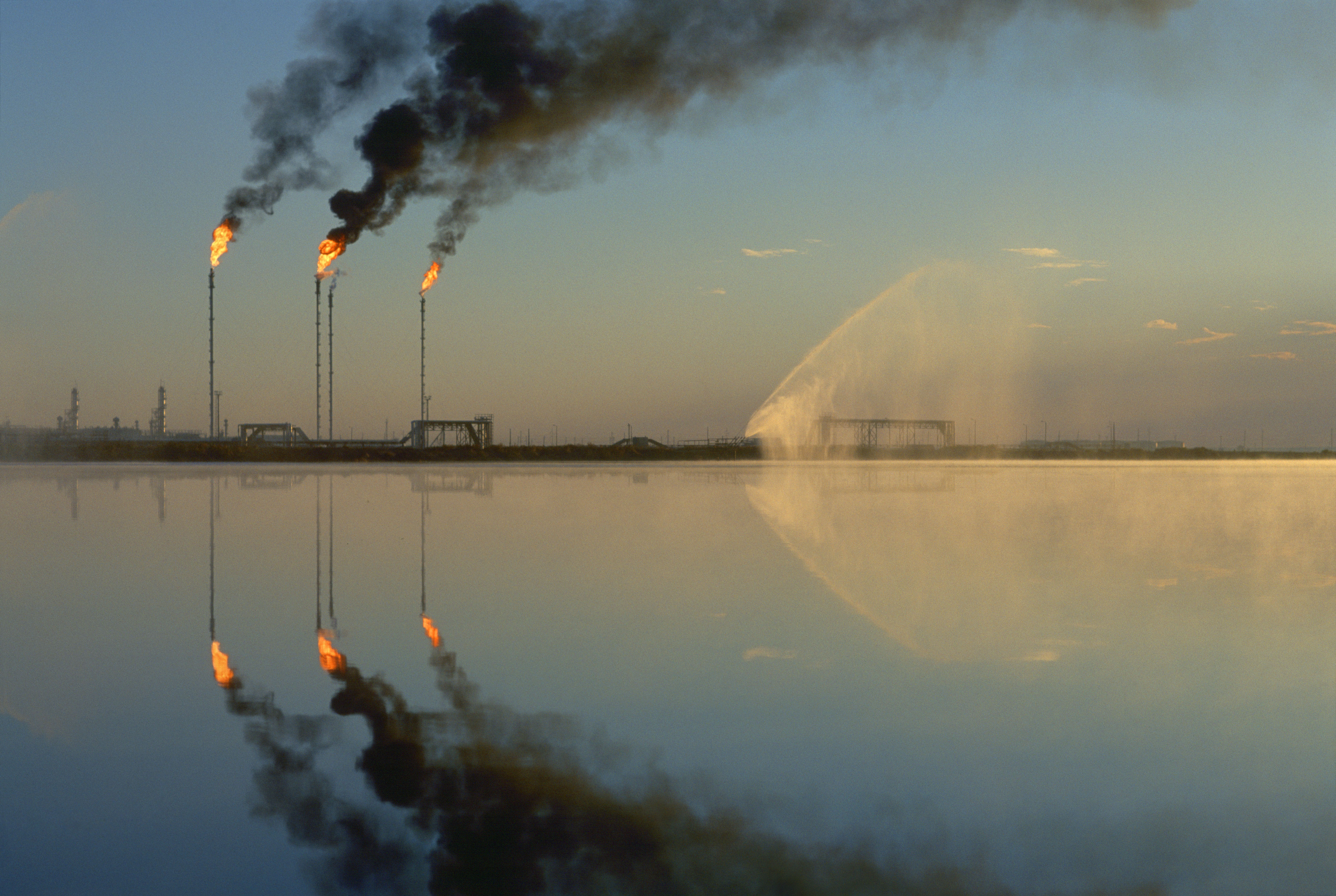 Fires burn from the tops of tall stacks at the Tengiz oil field, on the northeastern shore of the Caspian Sea on September, 1997 in Tengiz, Kazakhstan [Photo by Reza/Getty Images]