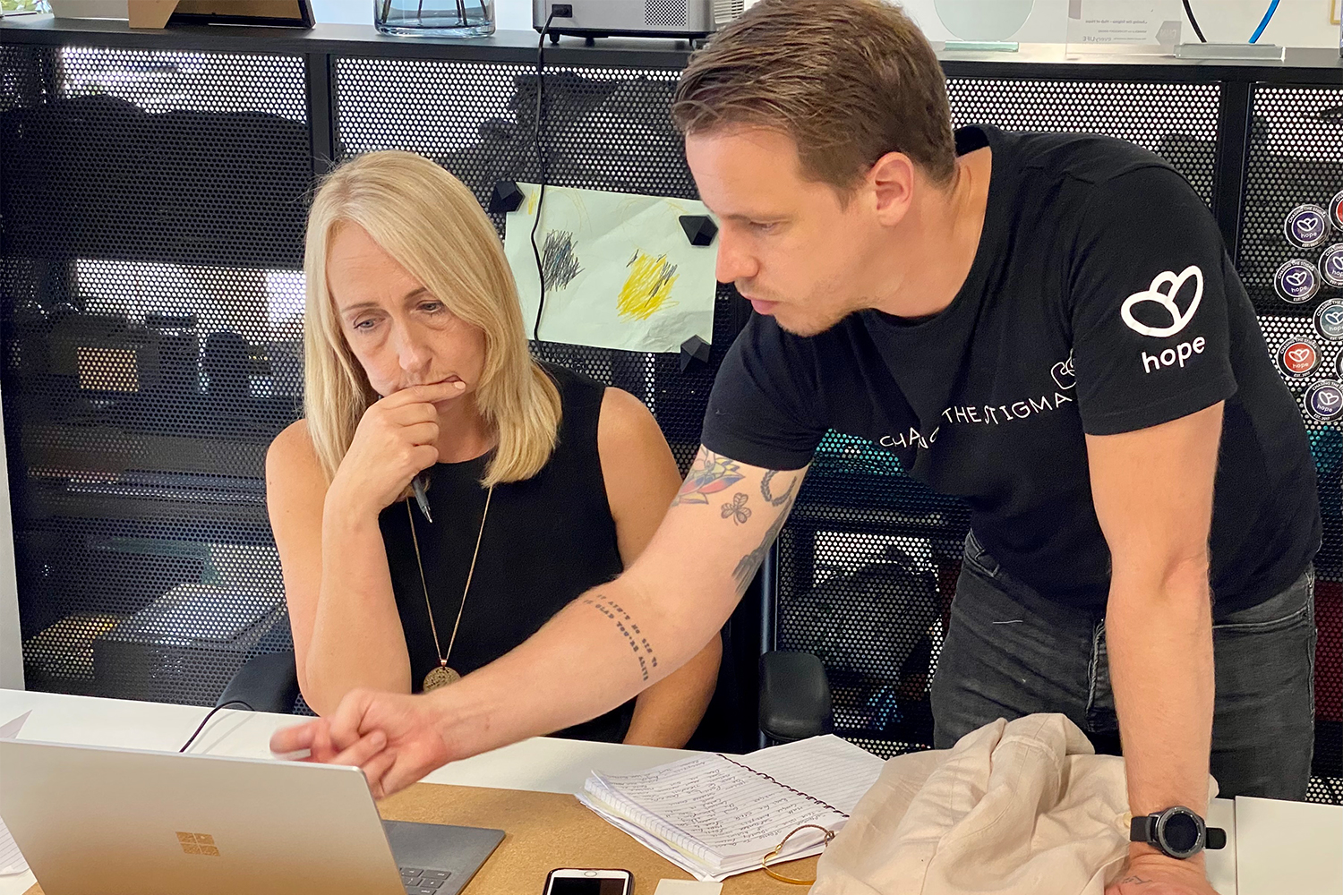 Jake Mills consulting with a colleague at the Chasing the Stigma offices in Liverpool