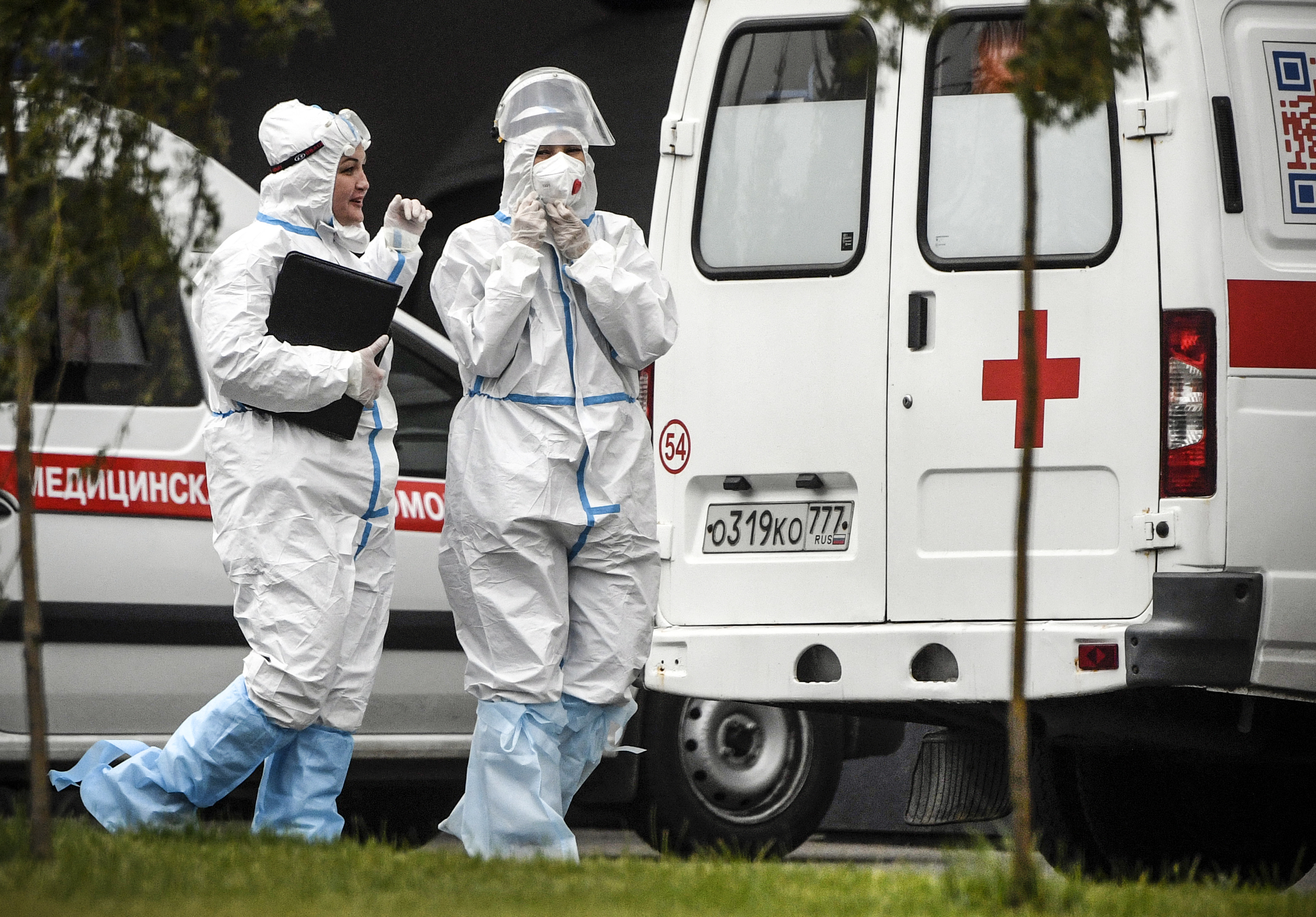 Medical staff members walk past ambulances at a hospital for COVID-19 infected patients at Kommunarka outside Moscow