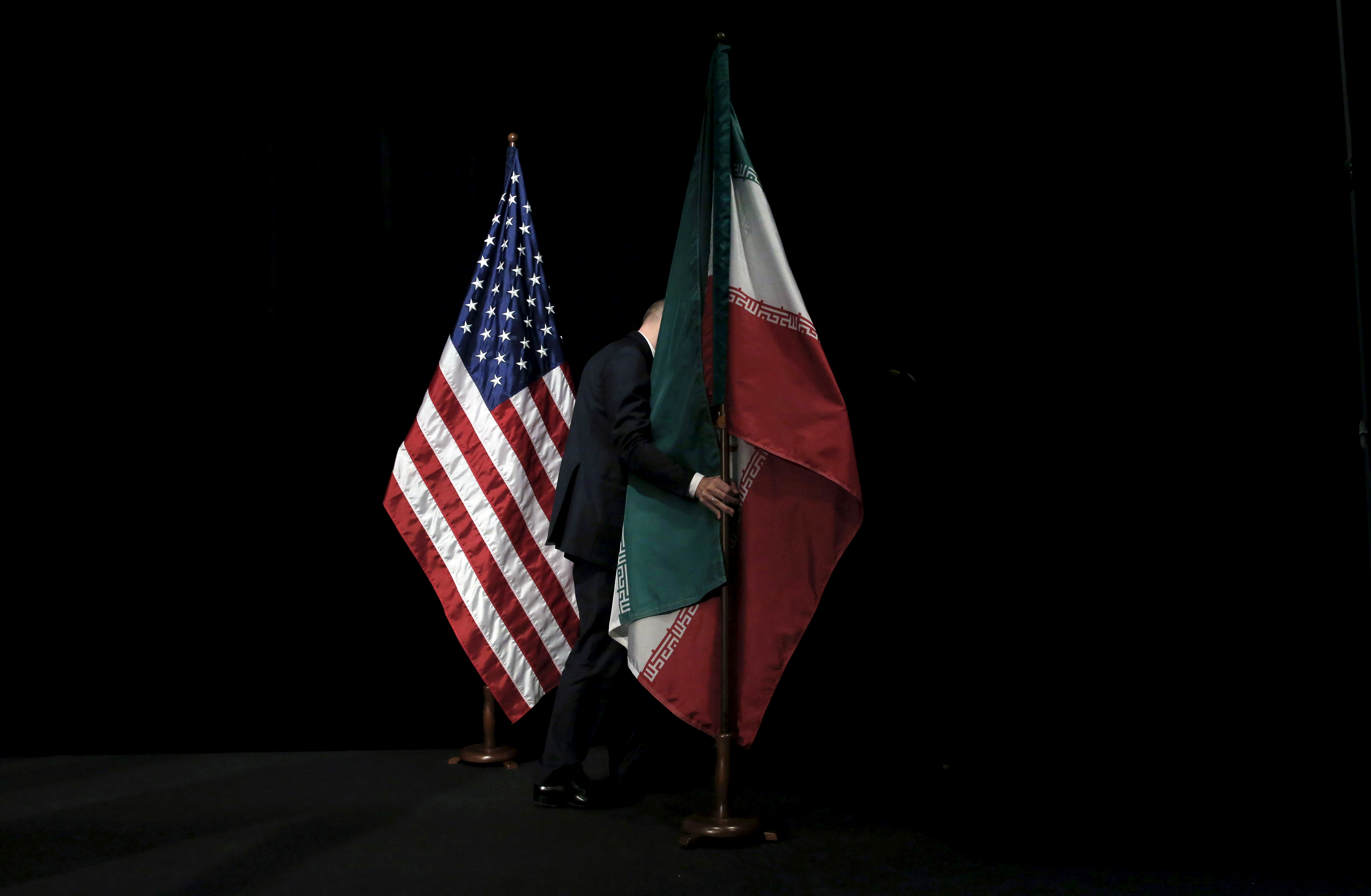 A staff member removes the Iranian flag from the stage after a group picture with foreign ministers and representatives of the US, Iran, China, Russia, Britain, Germany, France and the European Union during the Iran nuclear talks at the Vienna International Center in Vienna, Austria on July 14, 2015