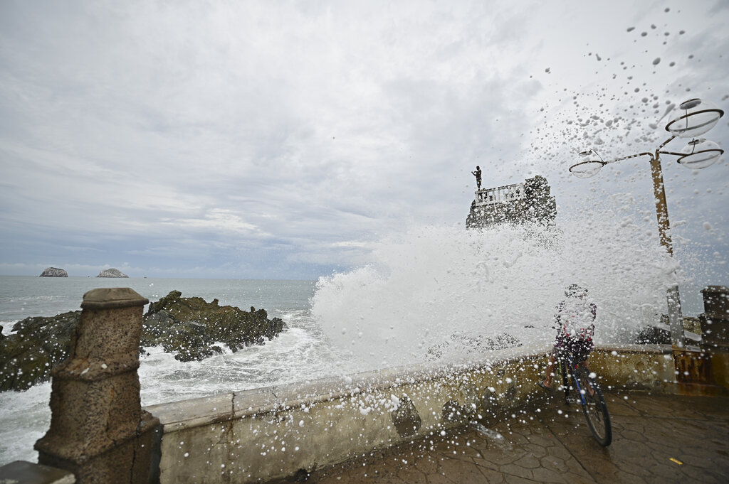 A cyclist is splashed by a crashing wave prior to Pamela making landfall, on the boardwalk in Mazatlan, Mexico