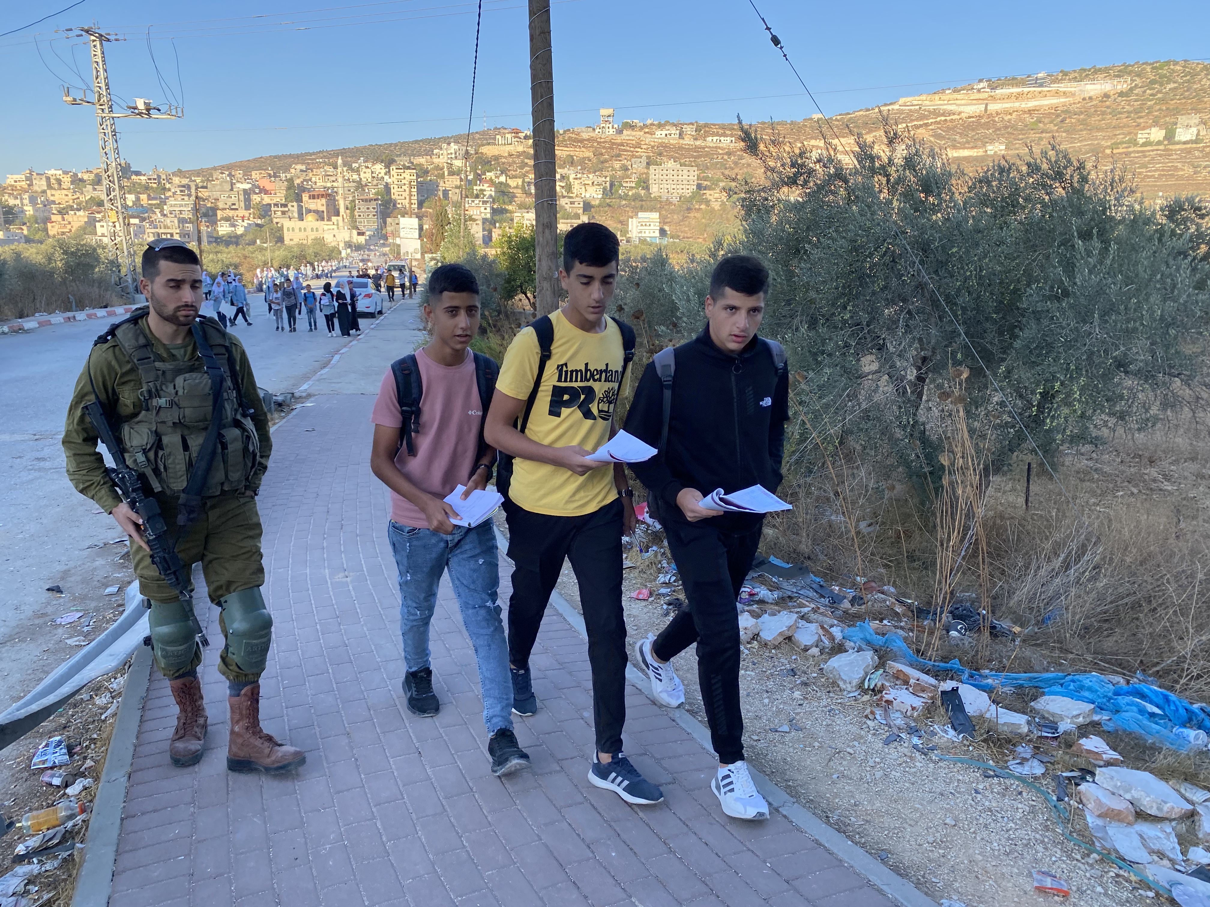 Palestinian schoolkids are forced to walk along a highway used by settlers to get to their school in Luban Asharqiya, in Nablus, northern occupied West Bank [Al Jazeera]