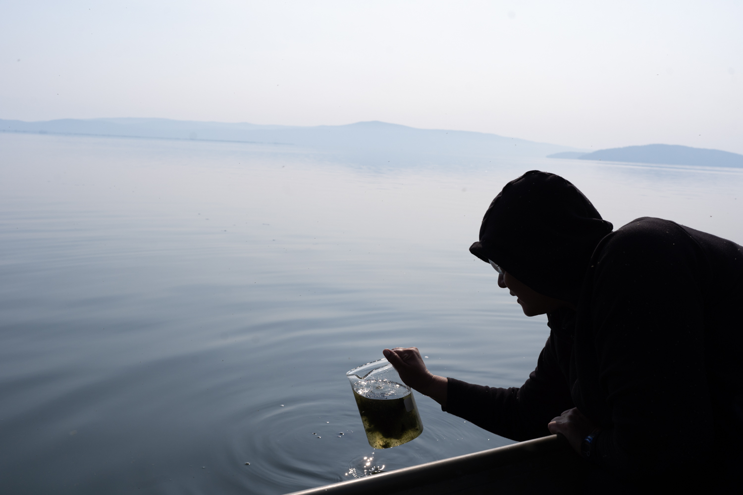 Joey Gentry collects water samples from the river. As algae blooms decompose they suck oxygen from the water, which affects the fish