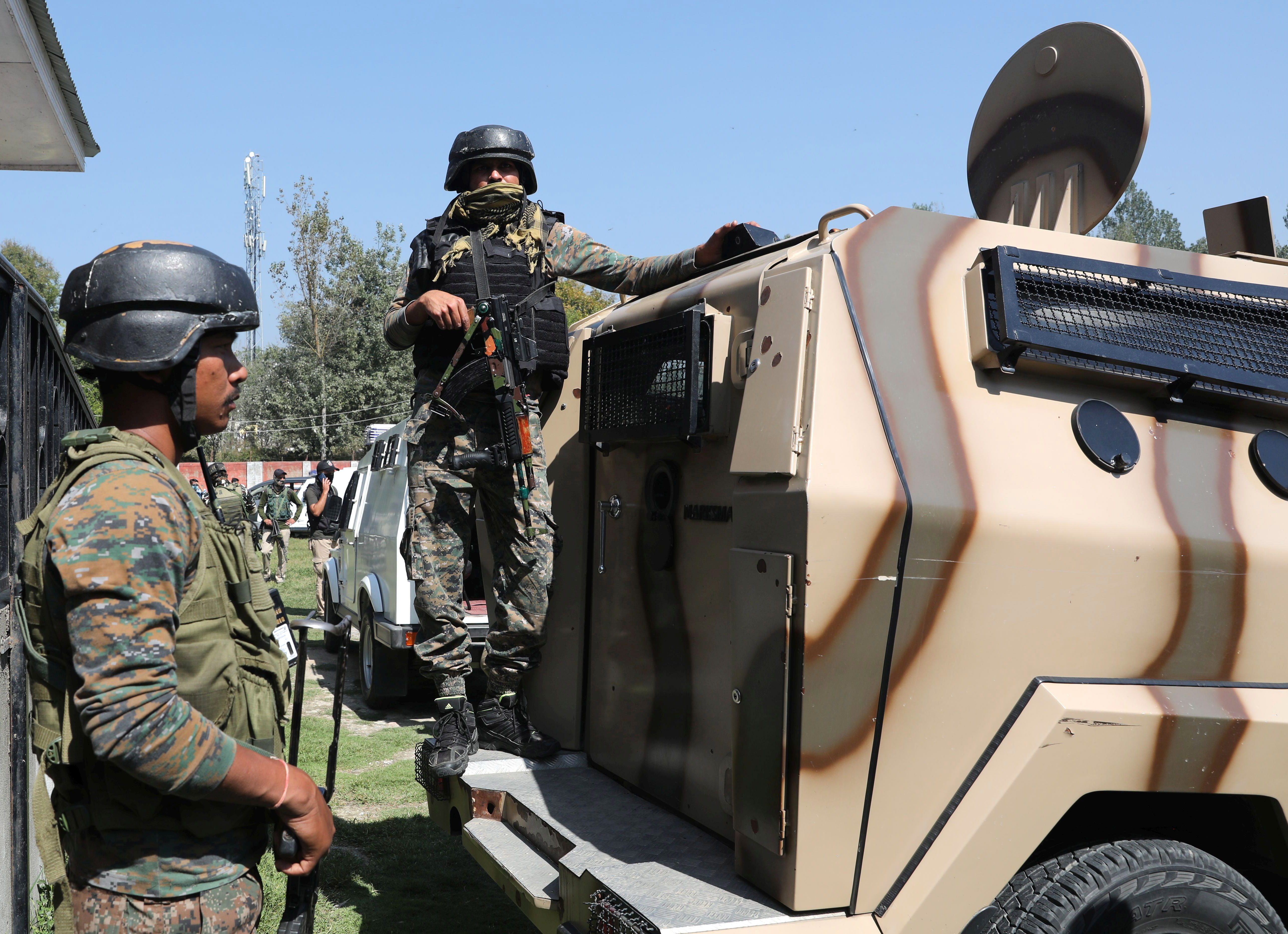 Indian paramilitary personnel stand guard inside the school campus where suspected rebels killed two school teachers on the outskirts of Srinagar
