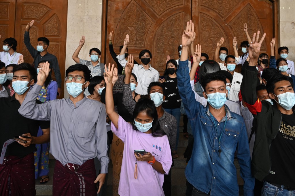 Students hold up three-finger salutes during a protest against the military coup at Dagon University in Yangon following the February 1 coup