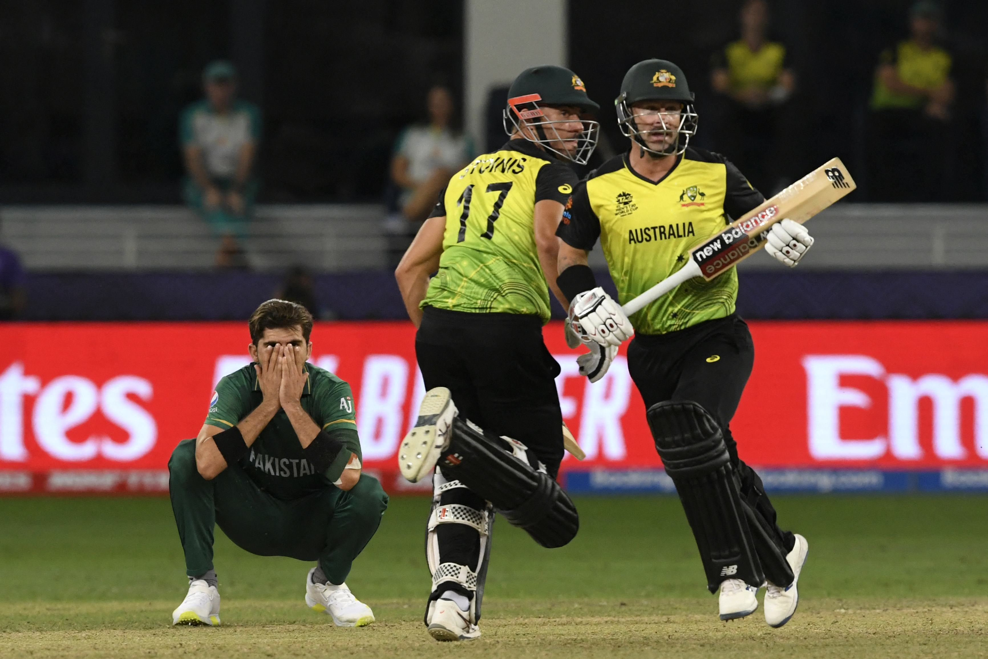Pakistan’s Shaheen Shah Afridi (L) reacts as Australia’s Marcus Stoinis (C) and Matthew Wade run between the wickets during the ICC mens Twenty20 World Cup semi-final match between Australia and Pakistan at the Dubai International Cricket Stadium in Dubai on November 11, 2021