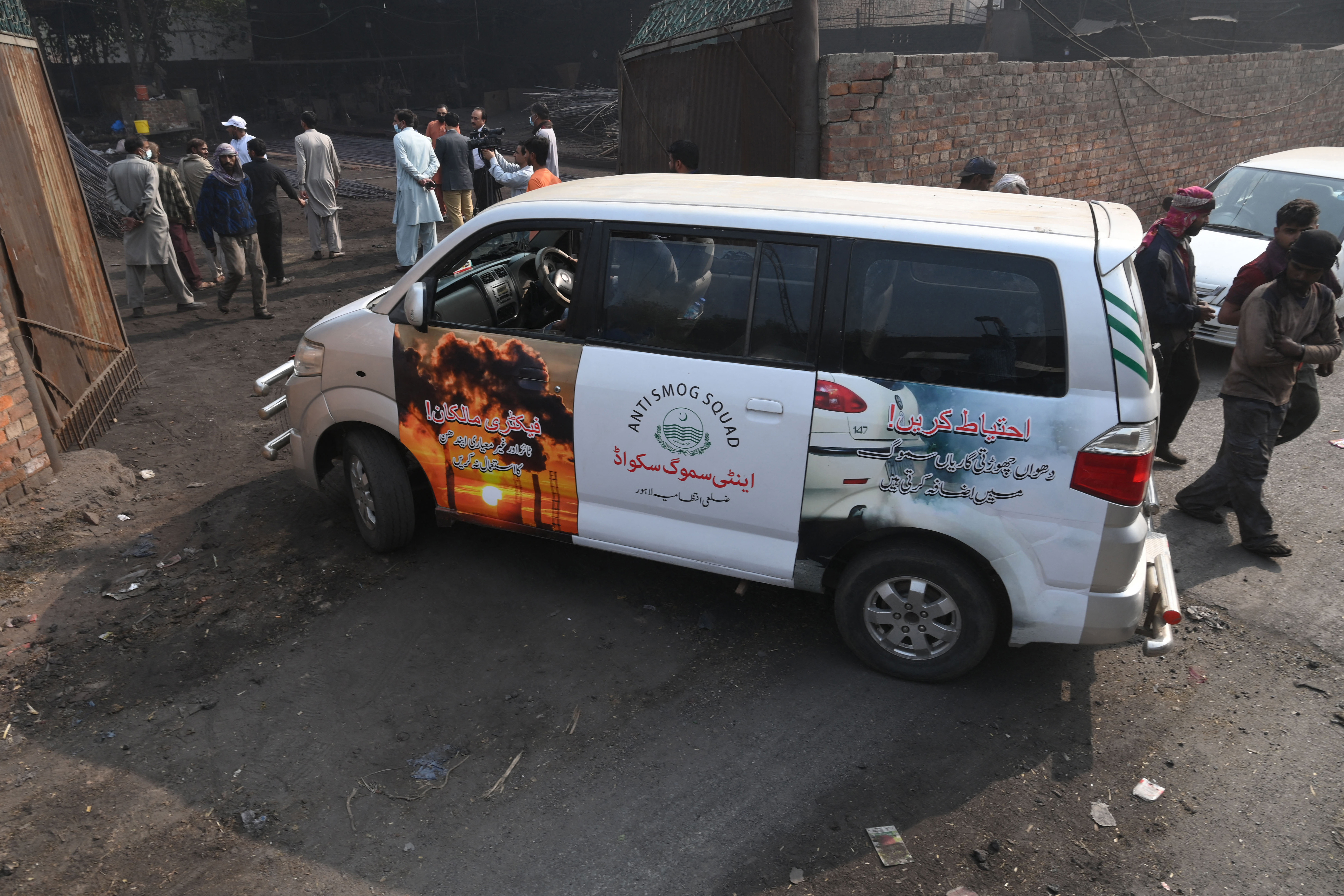 Officials inspect a steel factory following violating pollution norms in Lahore