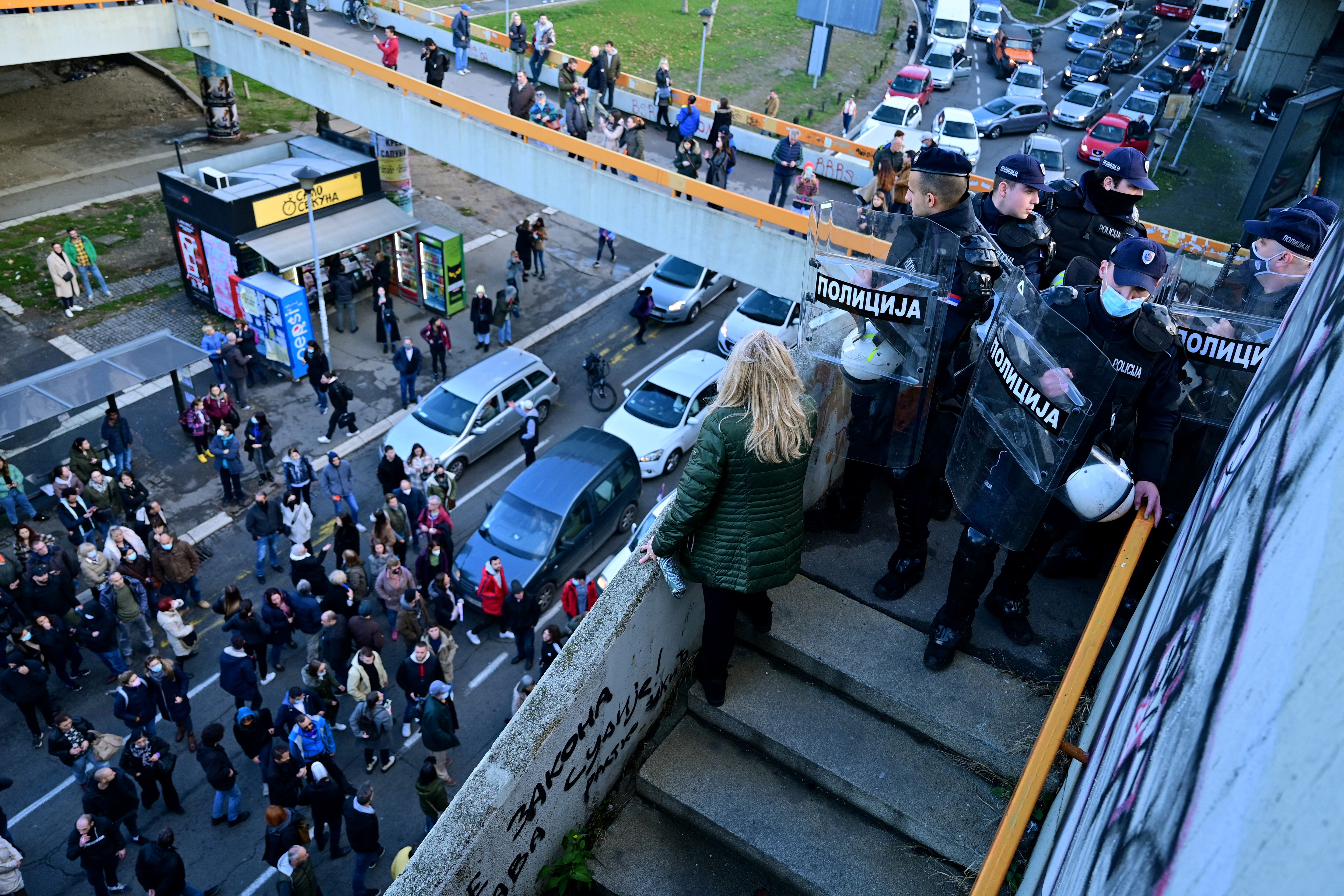 Police officers try to stop groups of environmental demonstrators from blocking the main highway in Belgrade
