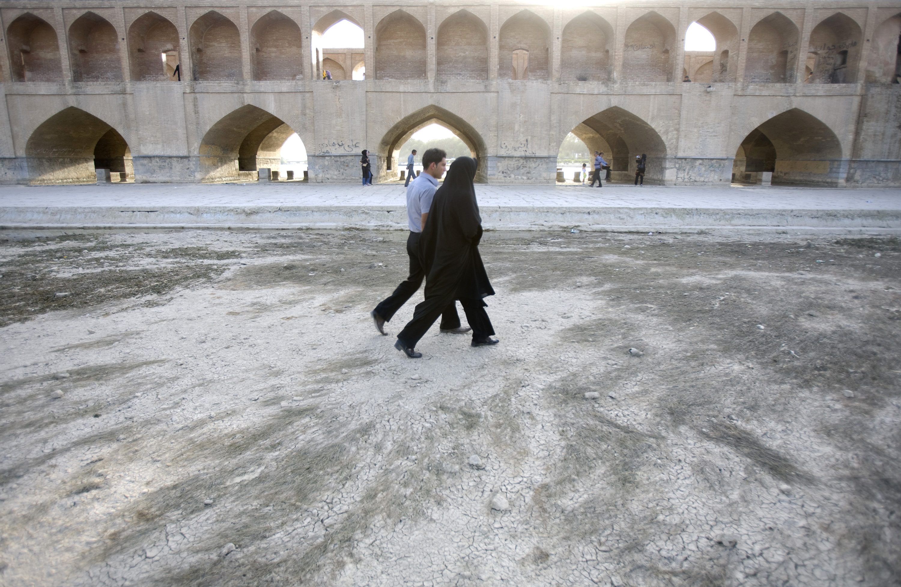 A couple walk on the dried-up Zayandeh Rud River in Isfahan, 450 km (281 miles) south of Tehran