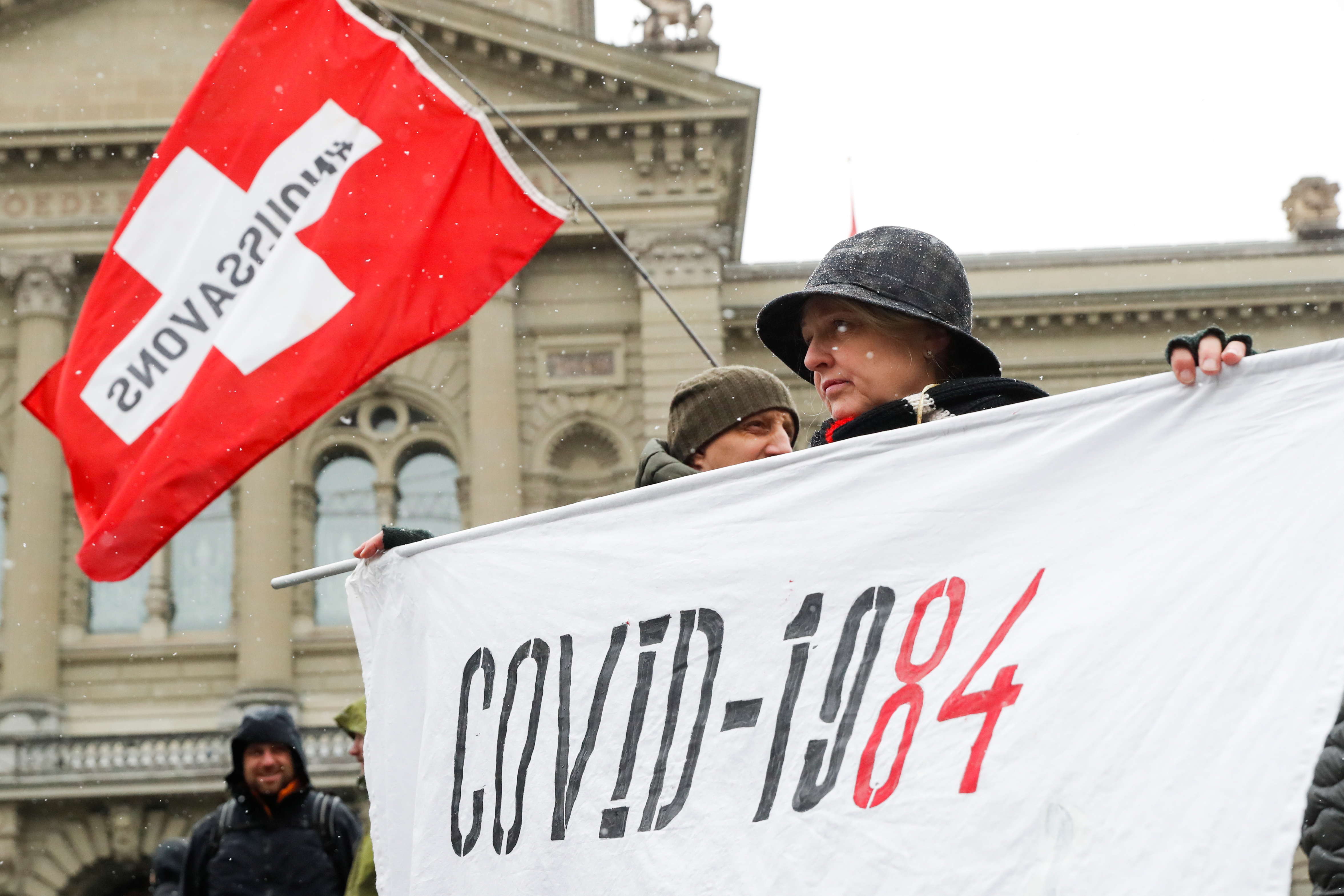 A woman holds a banner during a protest against a coronavirus [or COVID restrictions?] in Bern, Switzerland