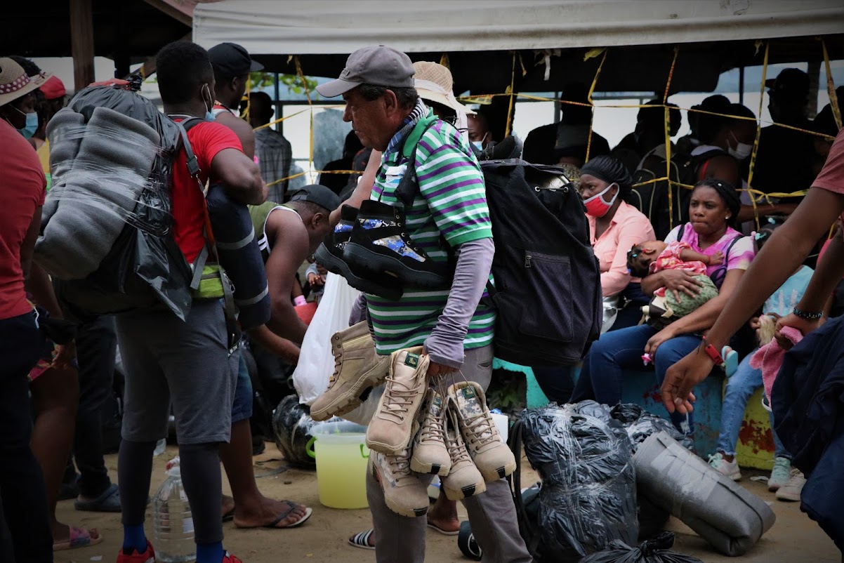 A Colombian man selling boots to people waiting to take the boat across the Gulf of Urabá to continue their journey north to the US