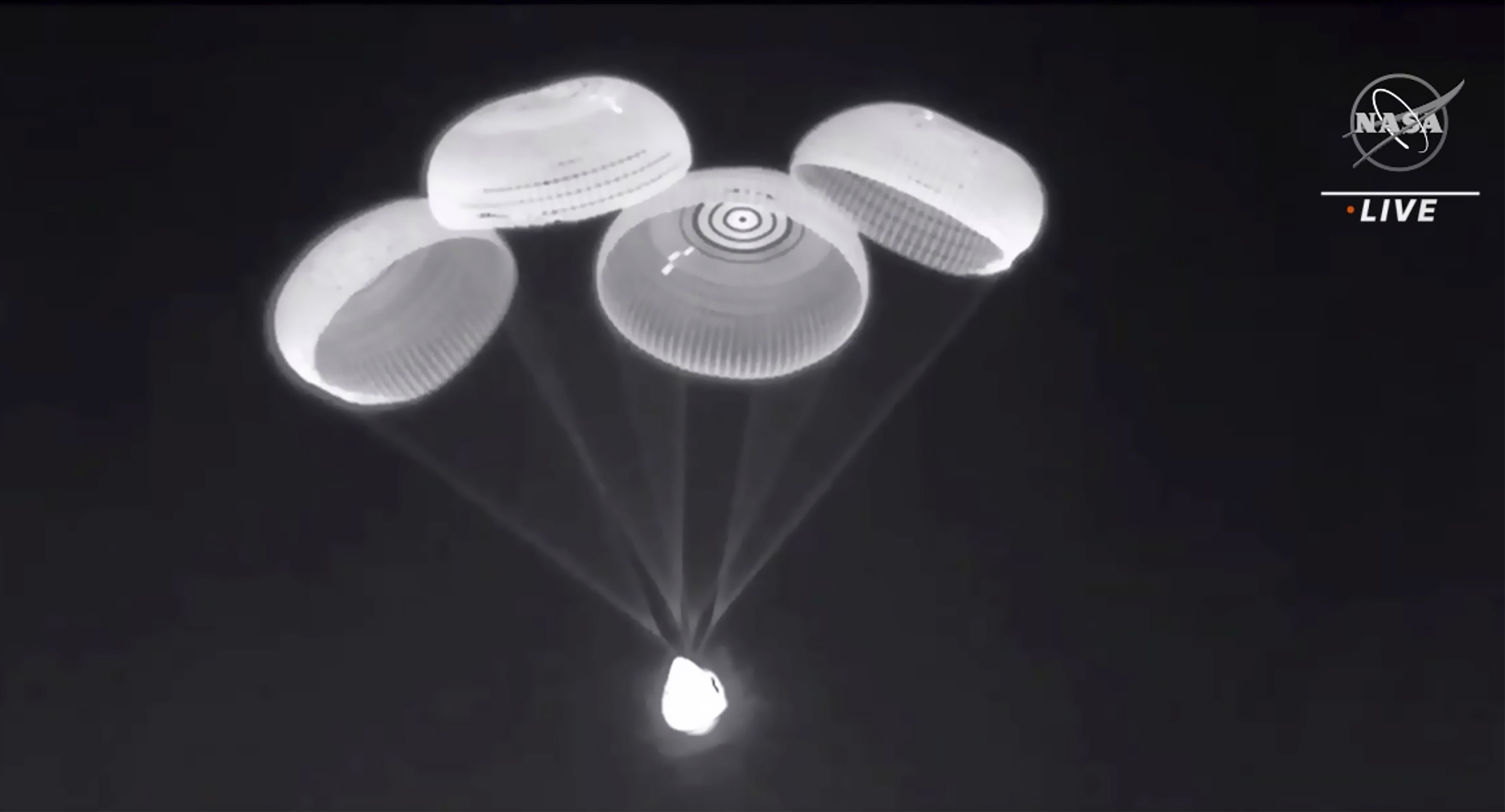 Parachutes are deployed from the SpaceX Dragon capsule to slow its descent [NASA via AP Photo]