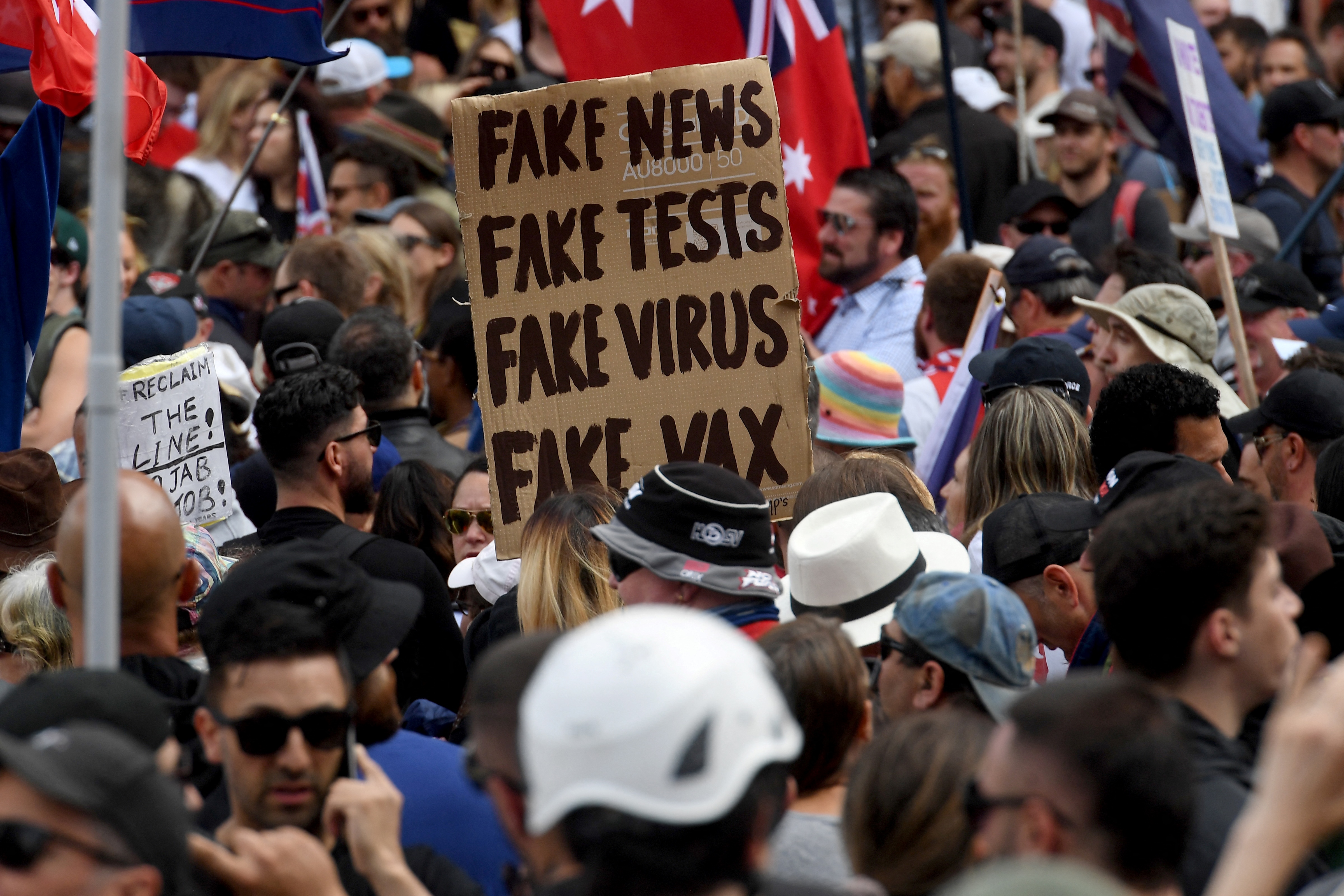 A protester holds up a placard during a rally against new pandemic laws and vaccination mandates in Melbourne