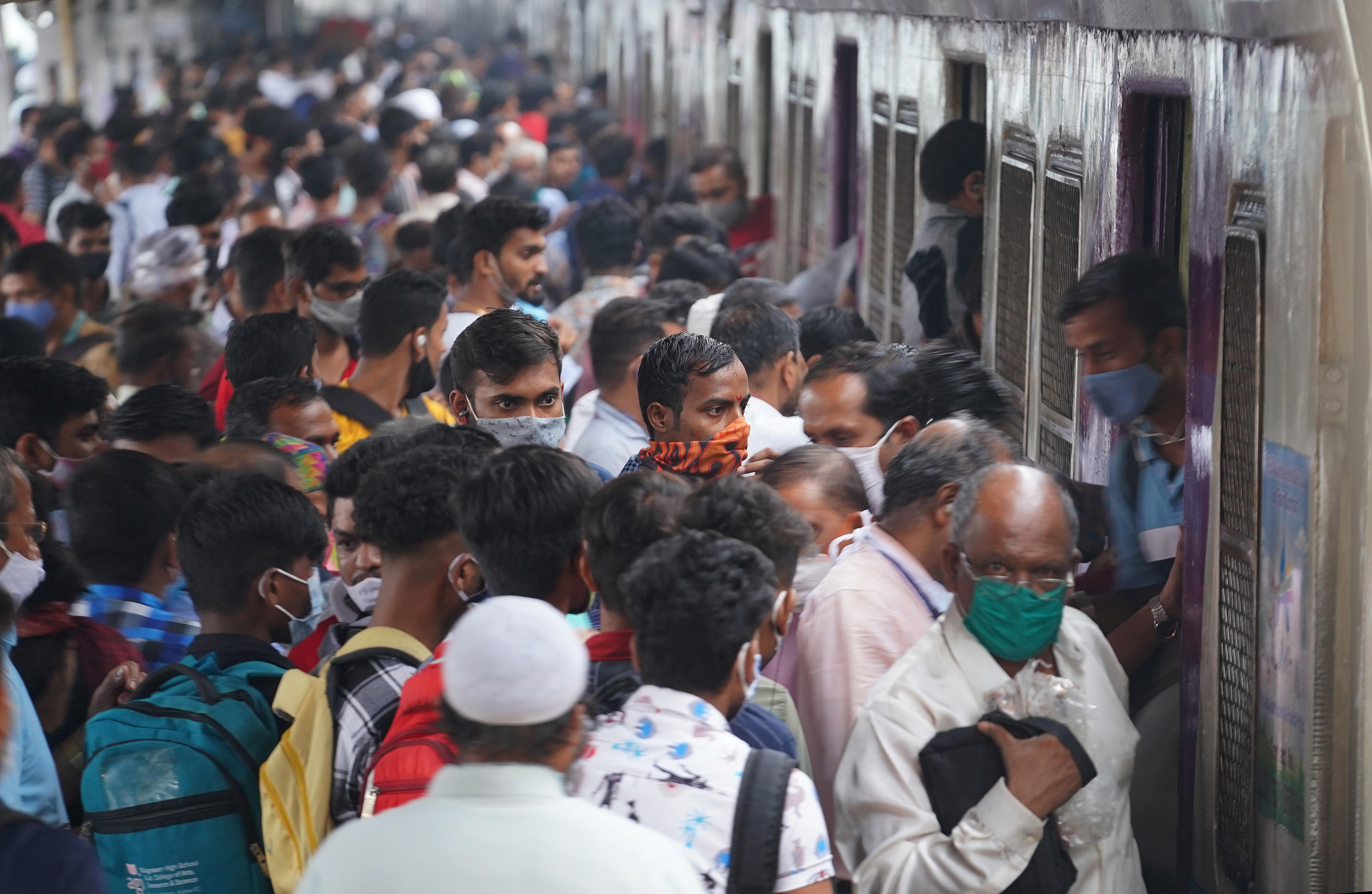 Commuters disembark from a suburban train at a railway station, amidst the coronavirus disease (COVID-19) pandemic, in Mumbai, India