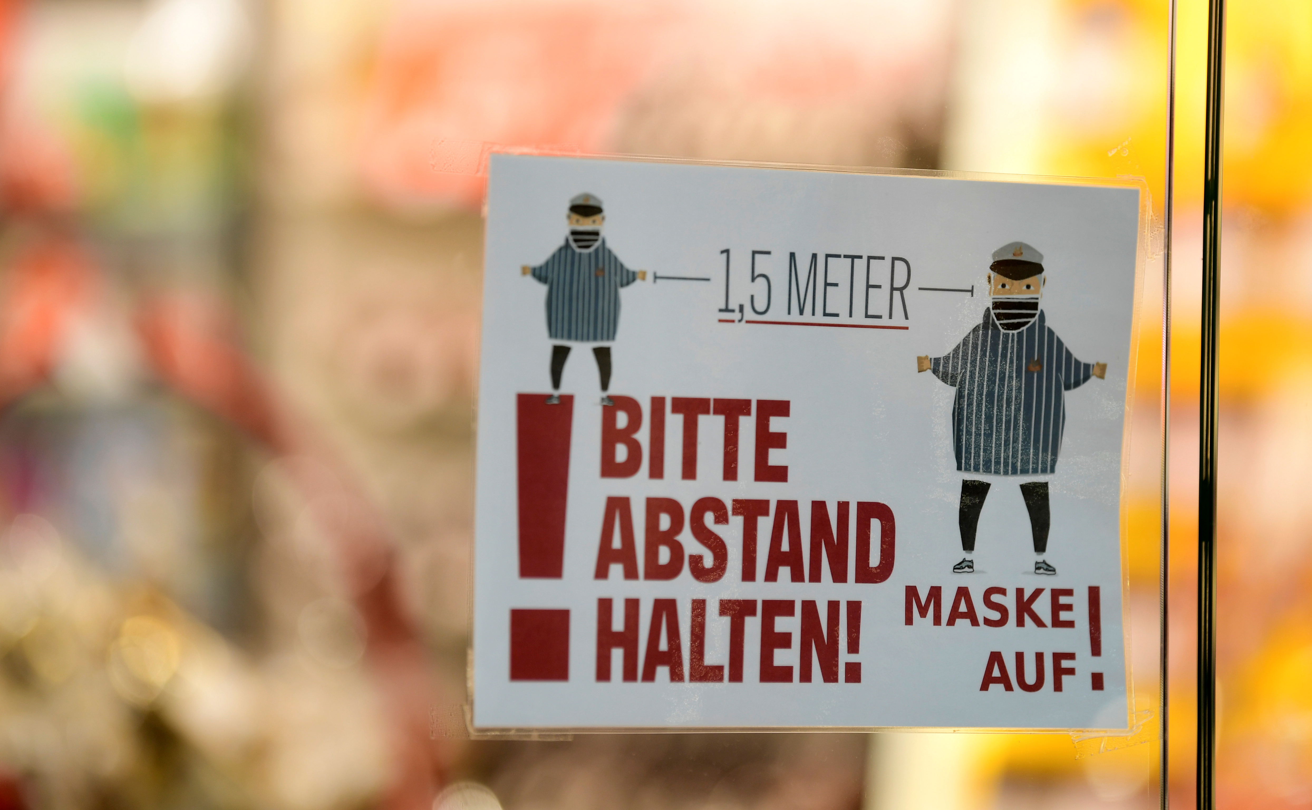 “Please keep your distance! Mask on!” read a sign on a shopping window of a mall shop in Hamburg, Germany