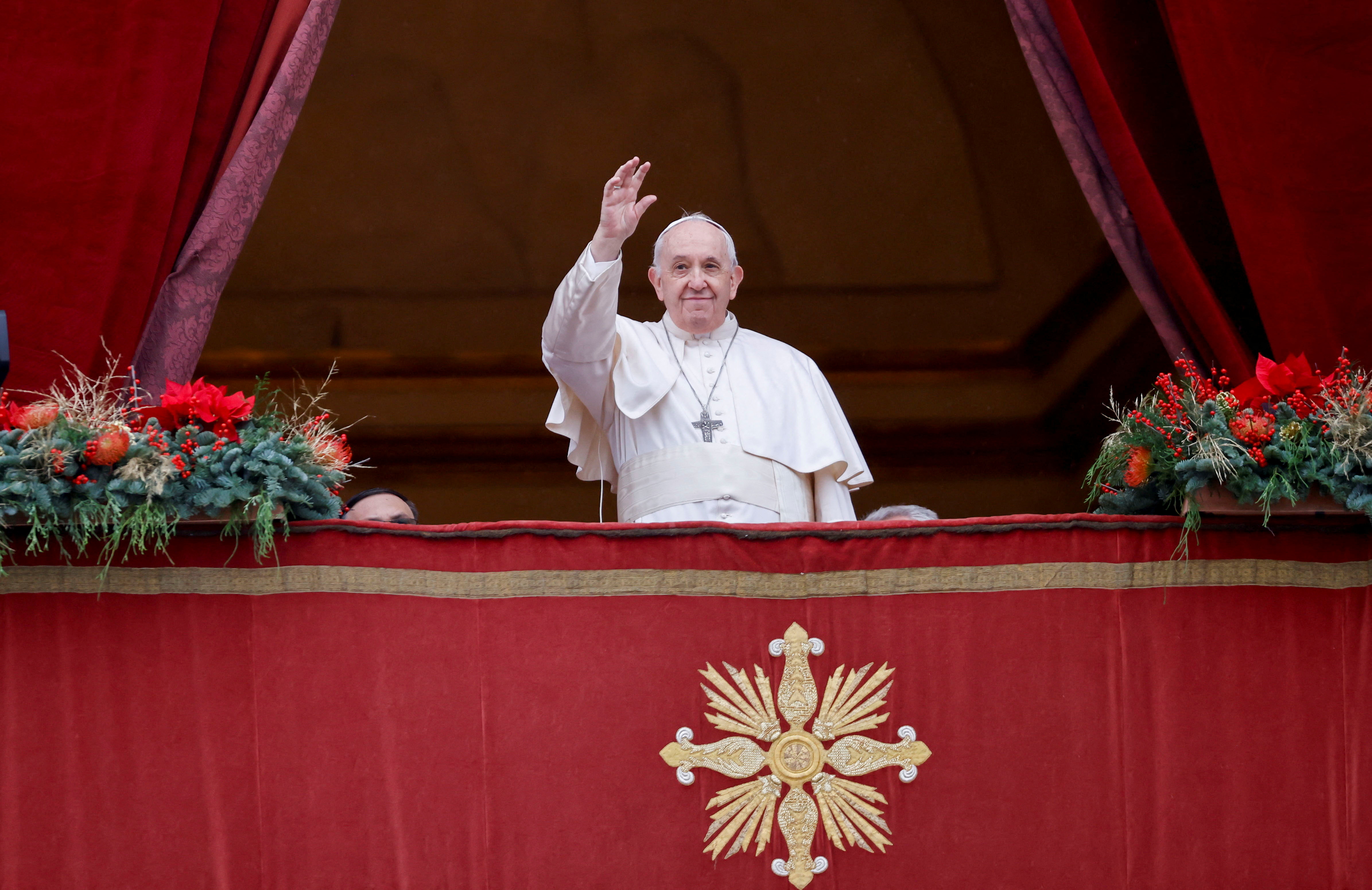 Pope Francis waves after delivering his traditional Christmas Day Urbi et Orbi speech to the city and the world from the main balcony of St. Peter’s Basilica at the Vatican, December 25, 2021