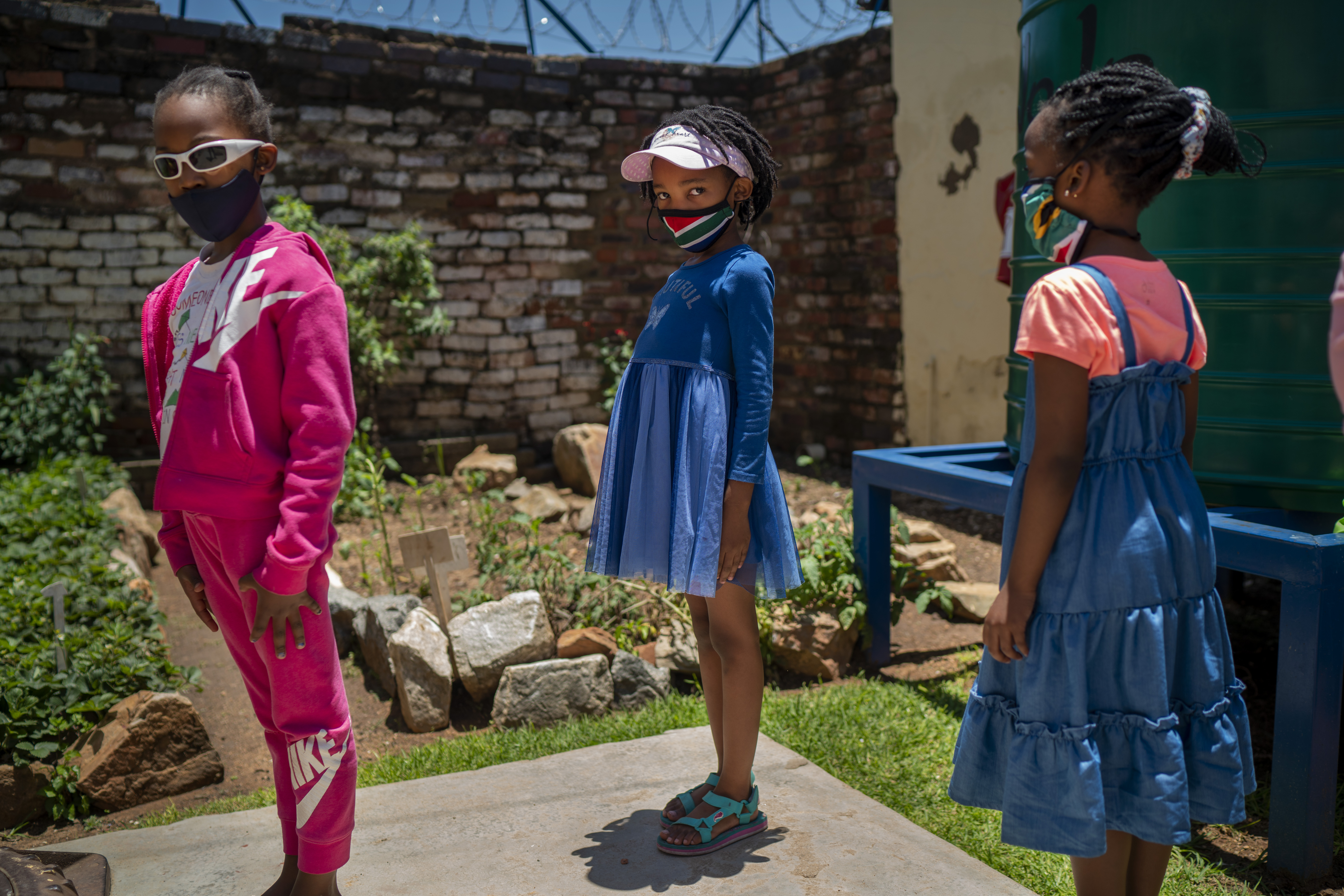 Pupils wearing masks line up to enter their classroom at the Kgololo Academy in Johannesburg’s Alexandra township