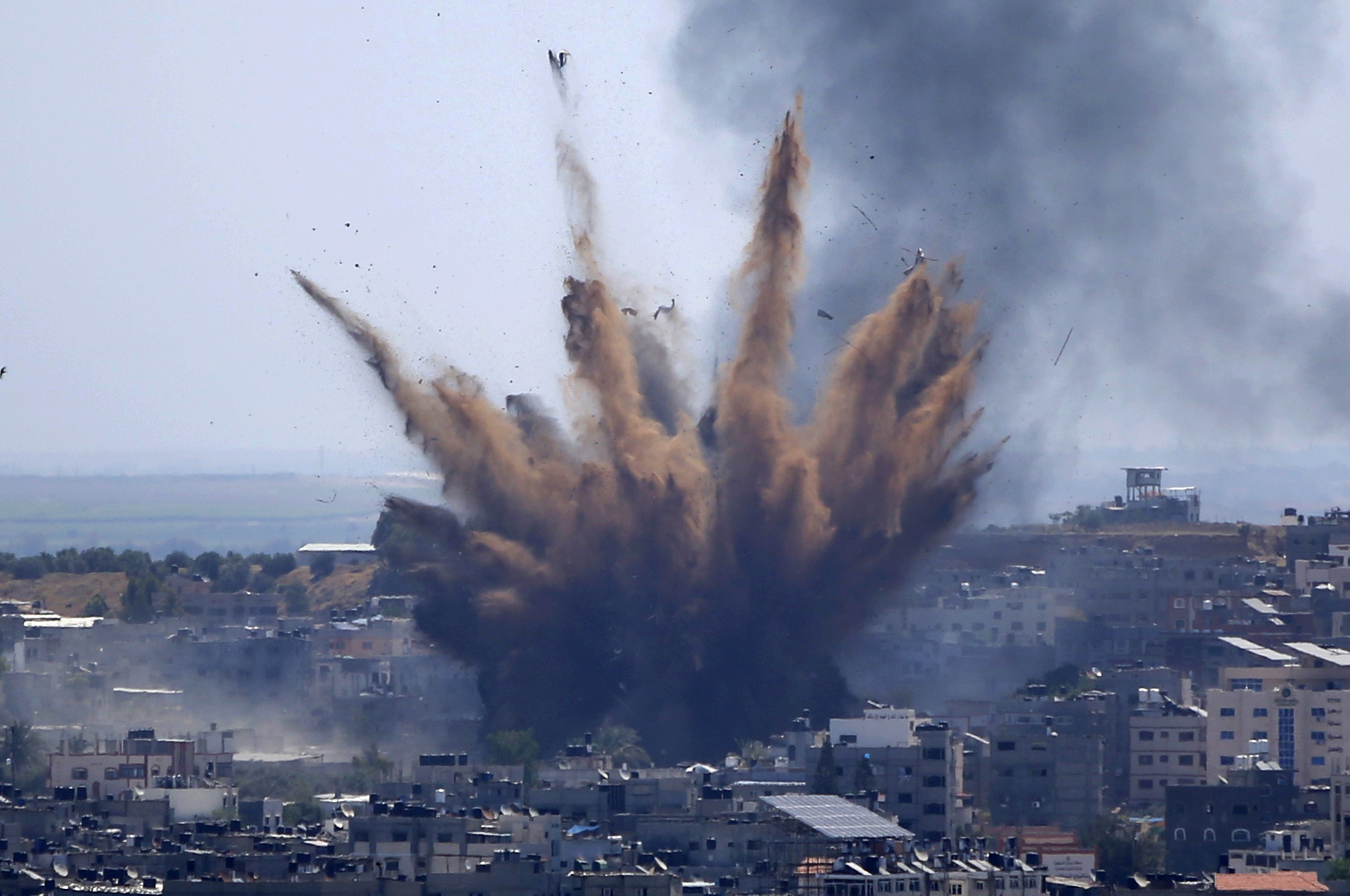 A blast from an Israeli air attack on a building in Gaza City throws dust and debris, May 13, 2021