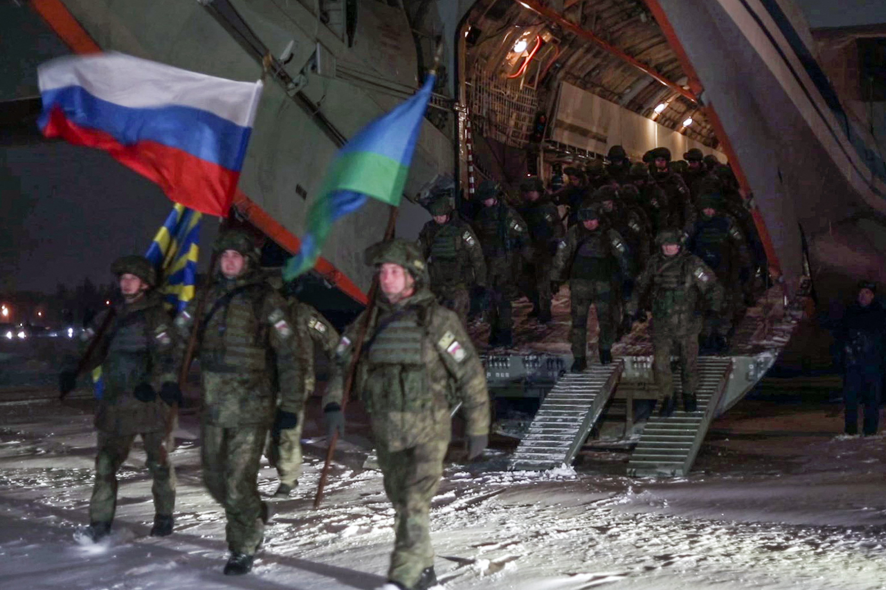Russian troops alighting from a military cargo plane upon landing in Ivanovo after completing their mission in Kazakhstan