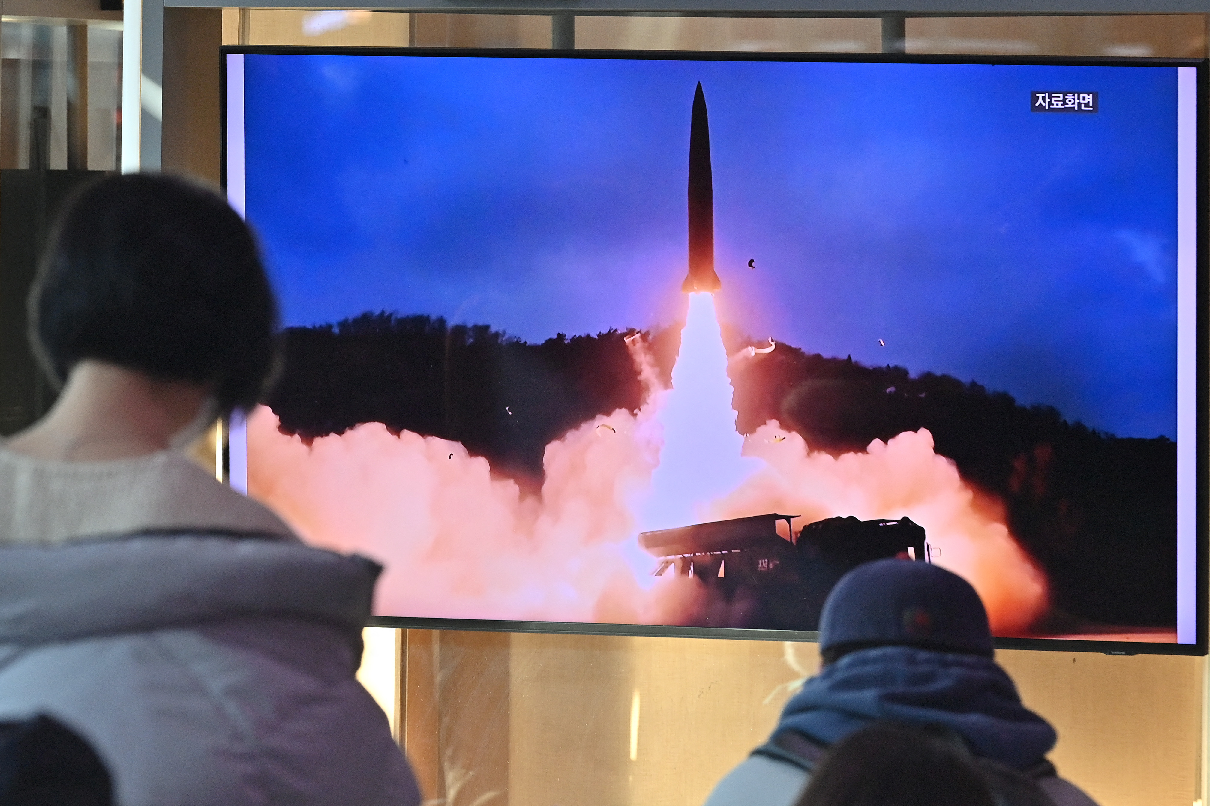 People in South Korea watch a television screen showing a news broadcast with file footage of another North Korean missile test in late January