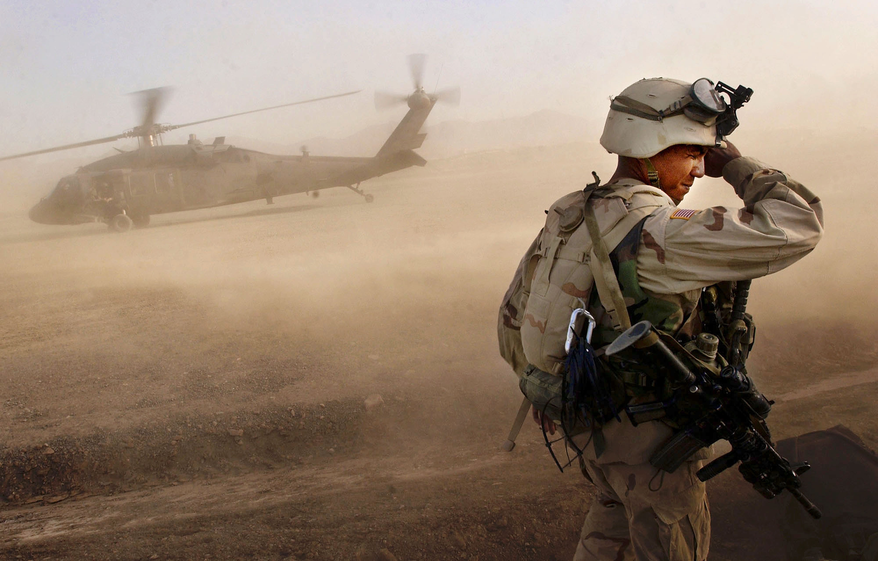 A soldier in the US 82nd Airborne Division turns away from a landing Black Hawk helicopter at a US Army base on October 3, 2002 at an undisclosed location in southeastern Afghanistan