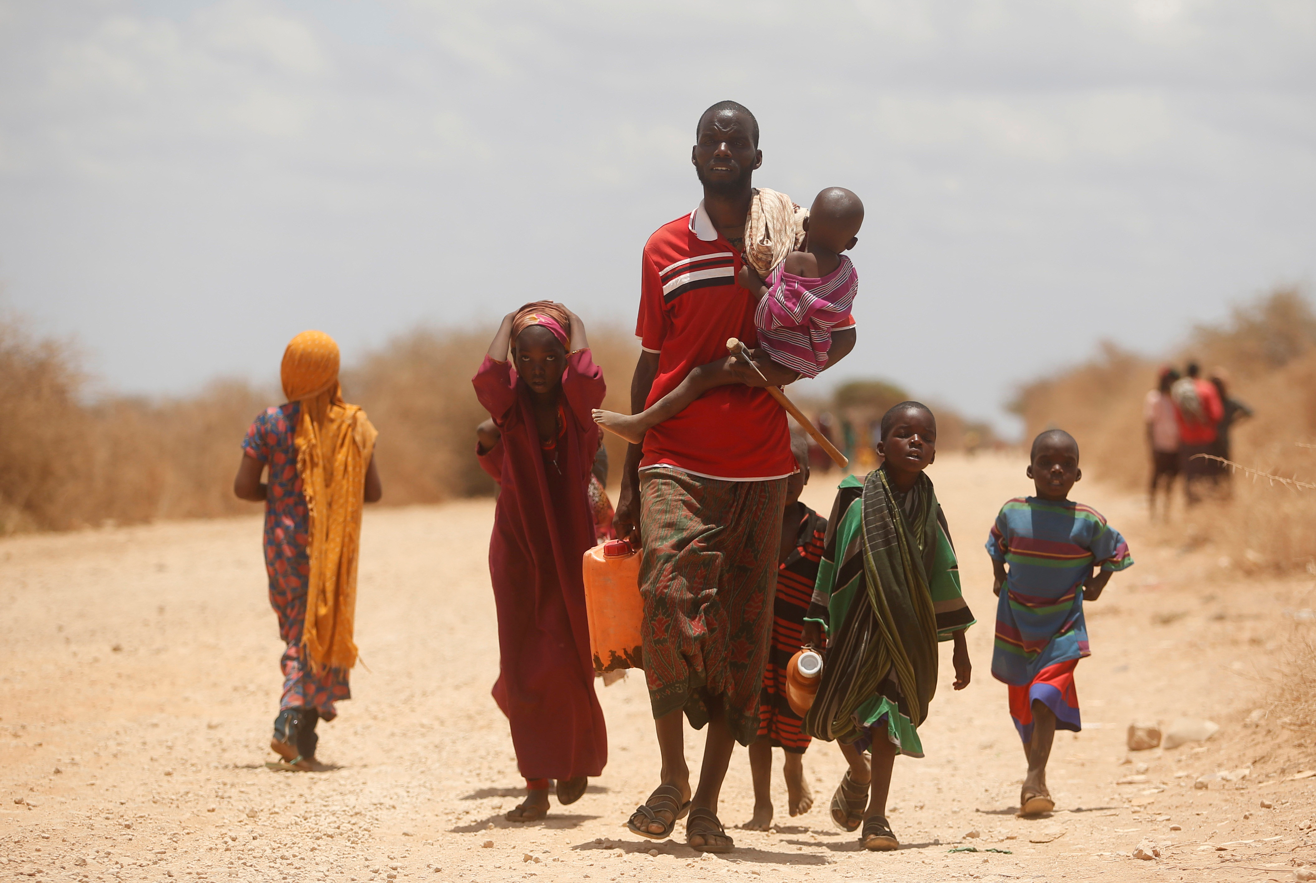 Internally displaced Somalis carry their belongings as they flee from drought stricken regions before entering makeshift camps in Baidoa, west of Somalia's capital Mogadishu
