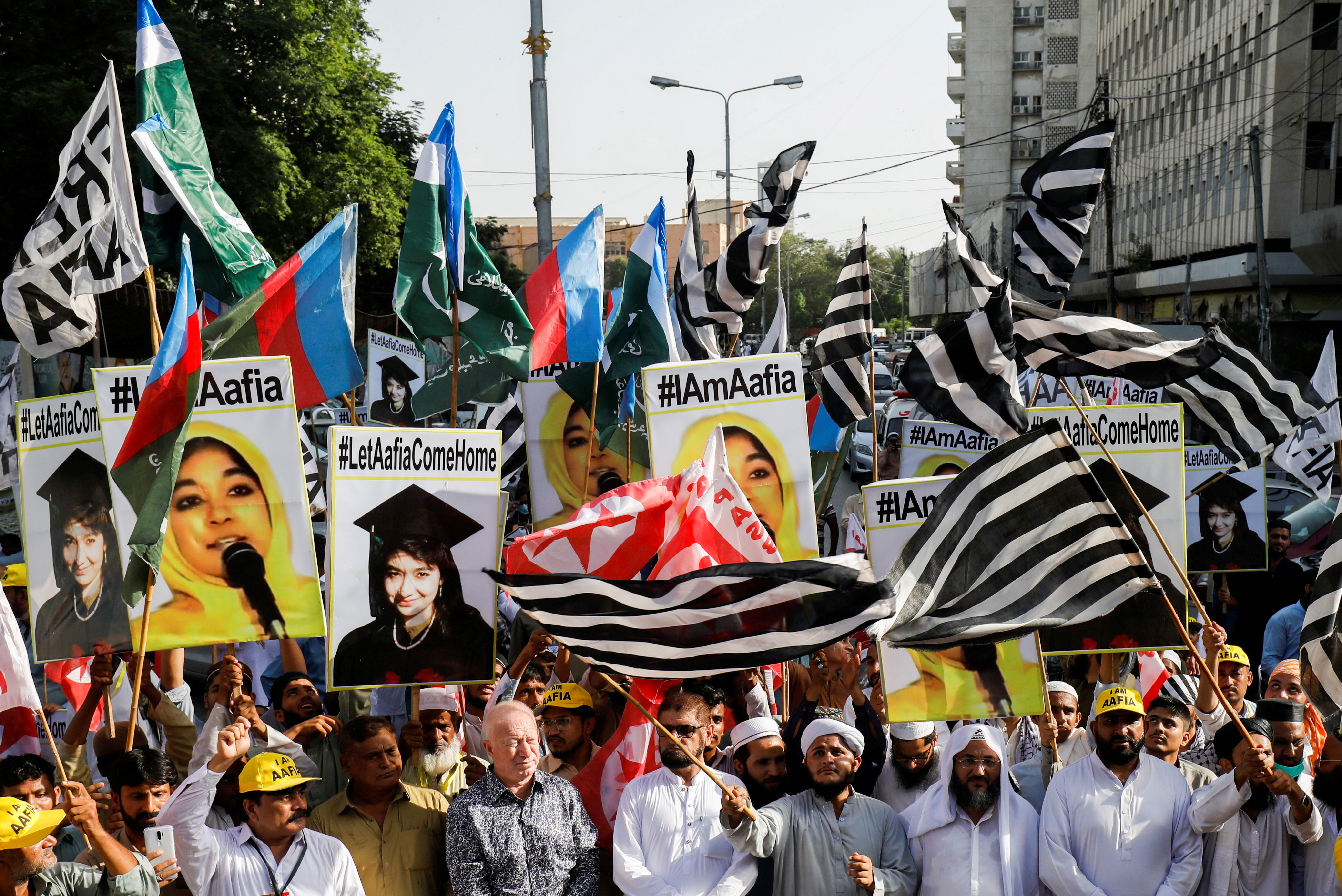 People carry flags and signs demanding the release of Aafia Siddiqui during a protest march in Karachi, Pakistan, on October 8, 2021