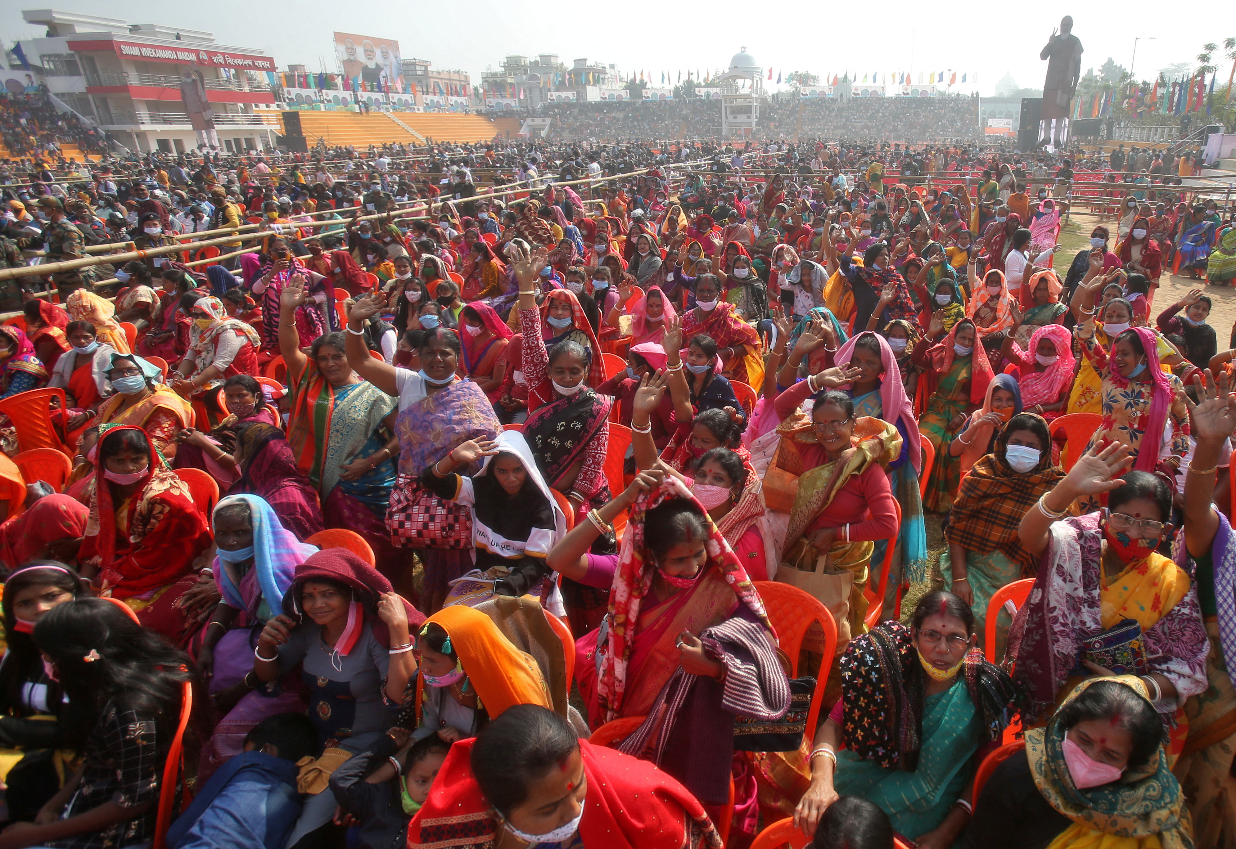 People wave as they attend a rally addressed by PM Narendra Modi in Agartala, Tripura
