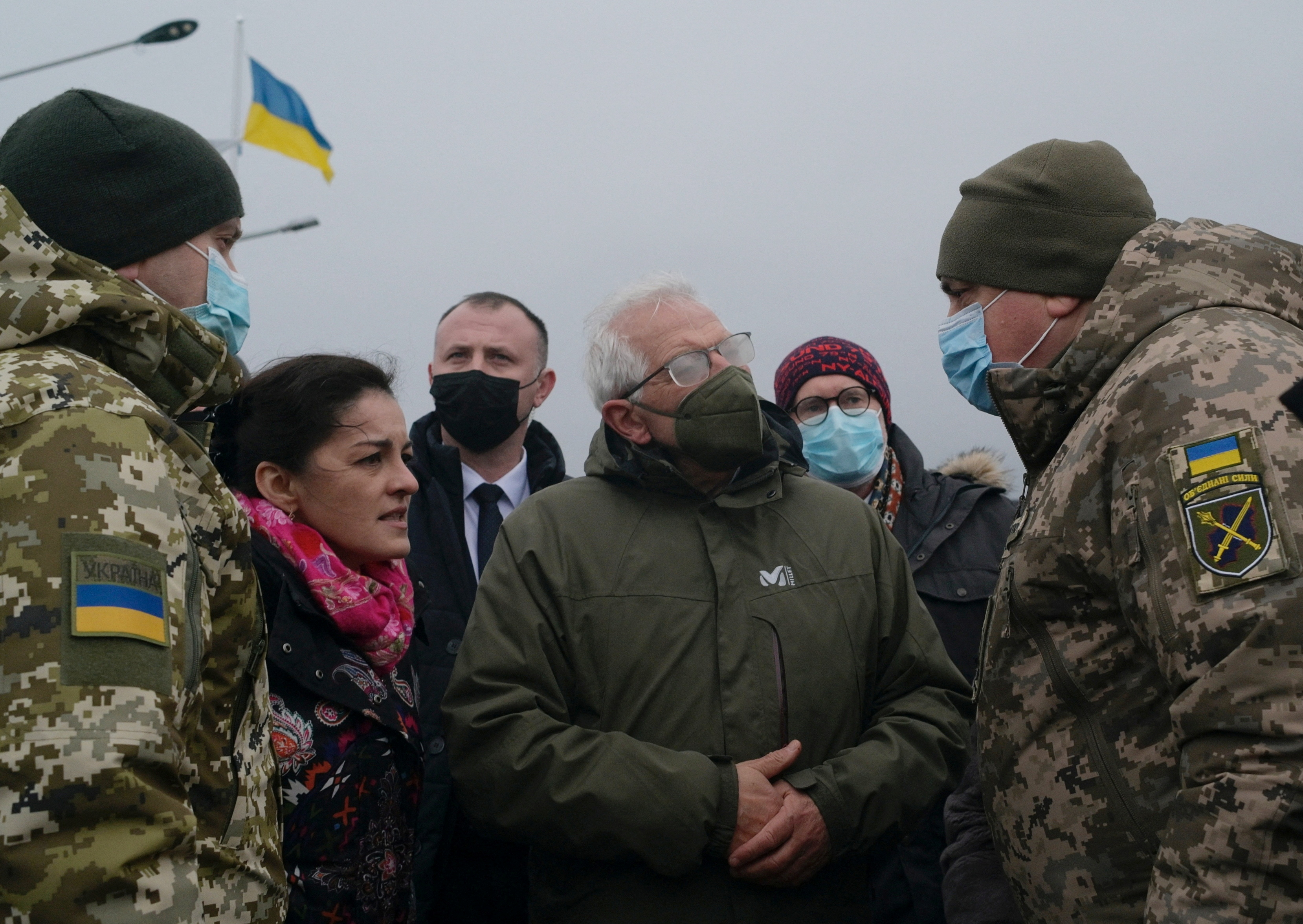 High Representative of the European Union for Foreign Affairs Josep Borrell talks to group of Ukrainians outside with a Ukrainian flag in the background