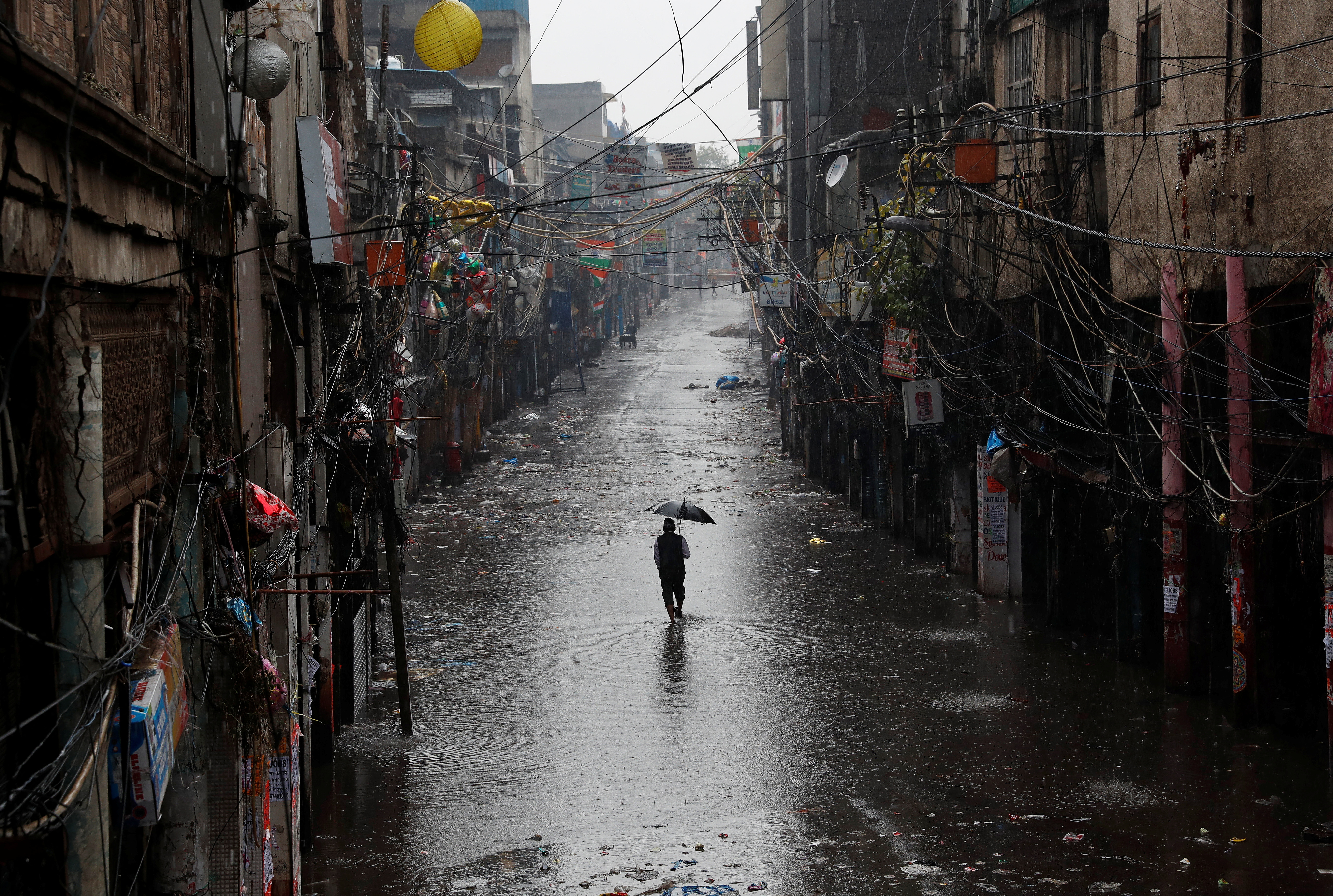 A person walks on a deserted road at a market after authorities in New Delhi ordered a weekend curfew, following the rise in COVID-19 cases
